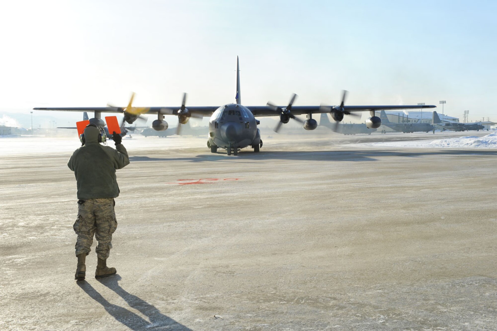 Alaska Air National Guard Senior Airman Alexander Van Nice, 176th Aircraft Maintenance Squadron, guides a C-130 Hercules aircraft into a parking position near Hangar 18, at Joint Base Elmendorf-Richardson, Saturday. (U.S. Air Force photo/Luke Waack)