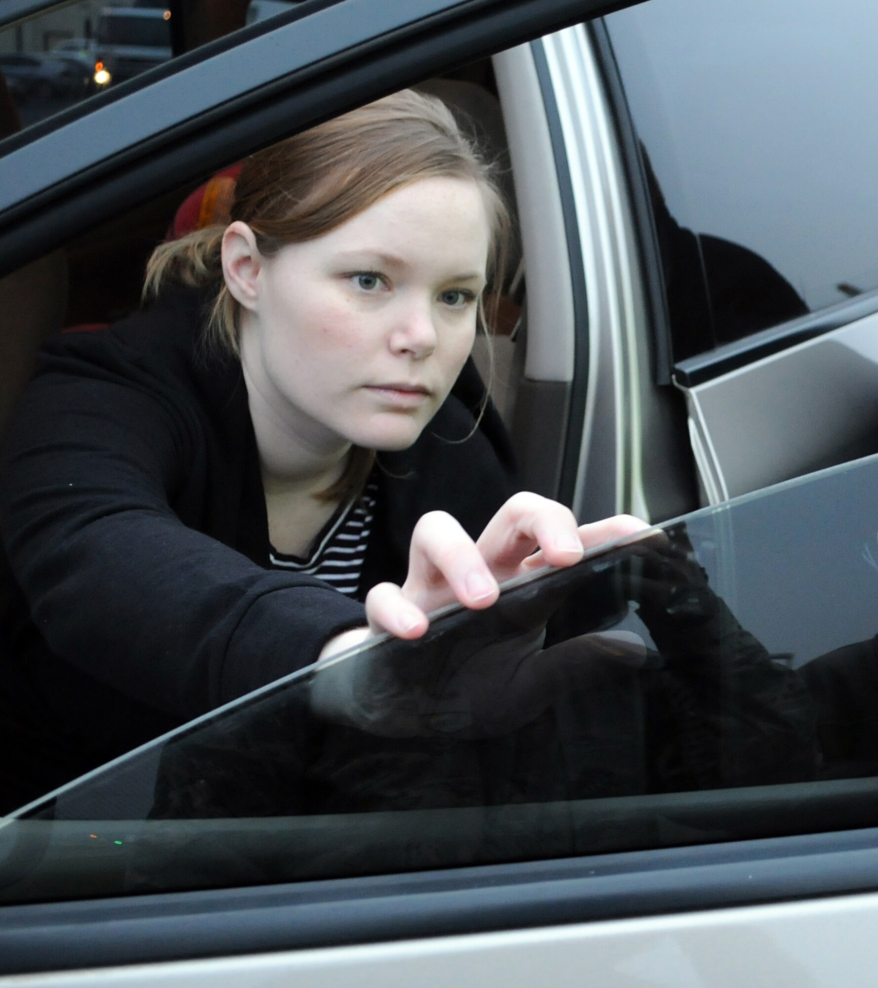 RAF MILDENHALL, England -- Melissa McKencie, 100th Mission Support Group, inspects the tint on her driver side window after it was tested for visible light transmission here Feb. 18, 2011.  United Kingdom law requires windshields to have a minimum light transmission of 75 percent and front-side windows 70 percent. Suffolk Police are carrying out a 30-day amnesty all over Suffolk and are offering free VLT tests. However, if stopped after March 9, 2011, vehicle-owners will be prosecuted. (U.S Air Force photo/Senior Airman Tabitha M. Lee)