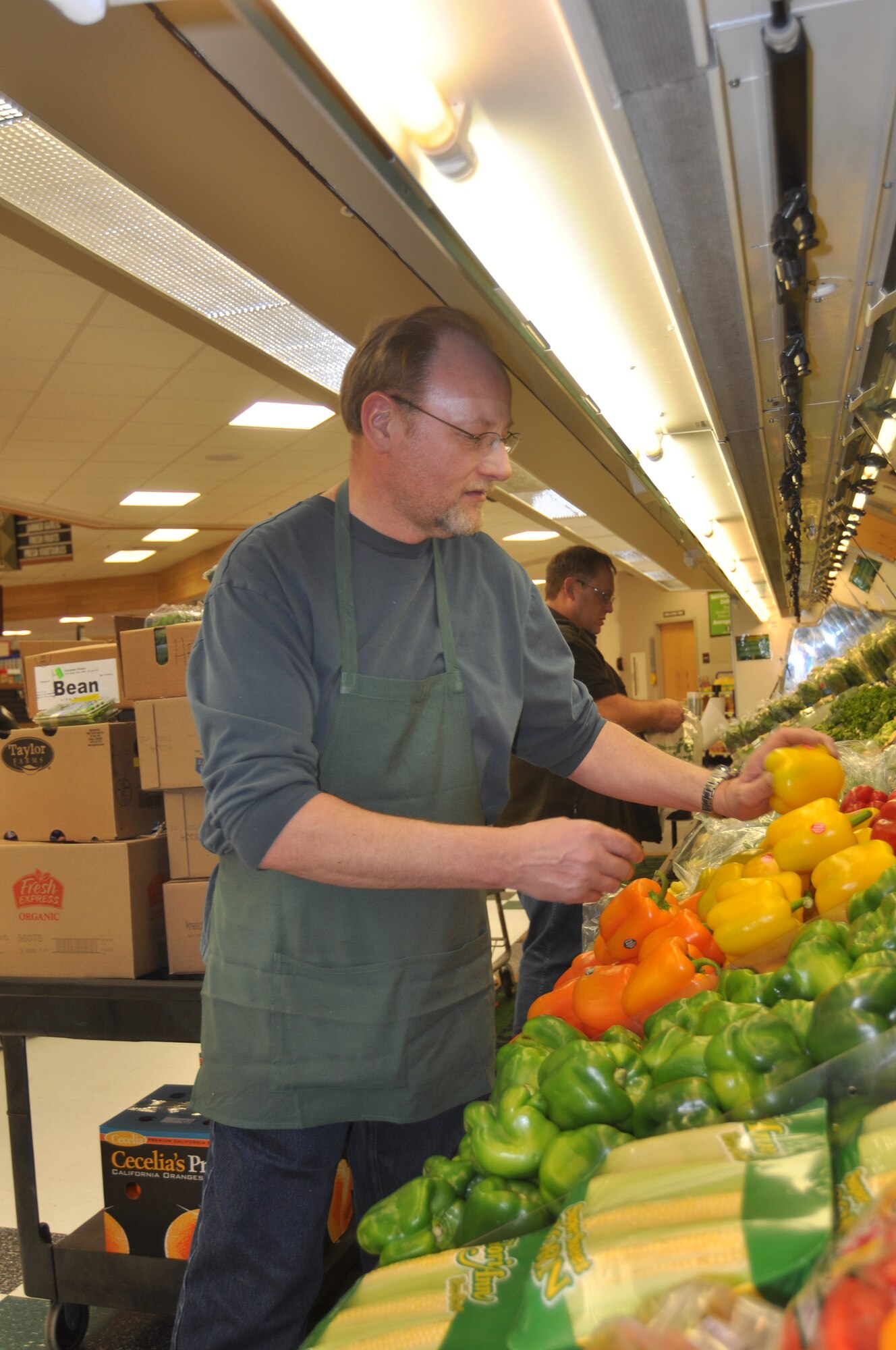 Darl Tischer, Fairchild Commissary produce manager, stocks produce at the commissary Feb. 11, 2011. Produce from the commissary will be one of many products offered Feb. 25 and 26 at the Grant County International Airport on-site sale. GCAI is located in Moses Lake, Wash. (U.S. Air Force Photo/ Scott King)