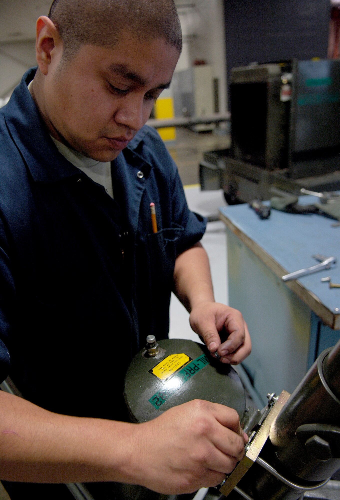 Staff Sgt. Gerard Quam, 92nd Maintenance Squadron aerospace ground equipment technician, cuts wire off of a tripod jack speed clamp and replaces it a plate and bolts Feb. 15, 2011 at Fairchild. He is replacing the clamp because the plate and bolts maintain the tripod jack better.  The tripod jack is used to life aircraft. (U.S. Air Force Photo/Senior Airman Natasha E. Stannard)