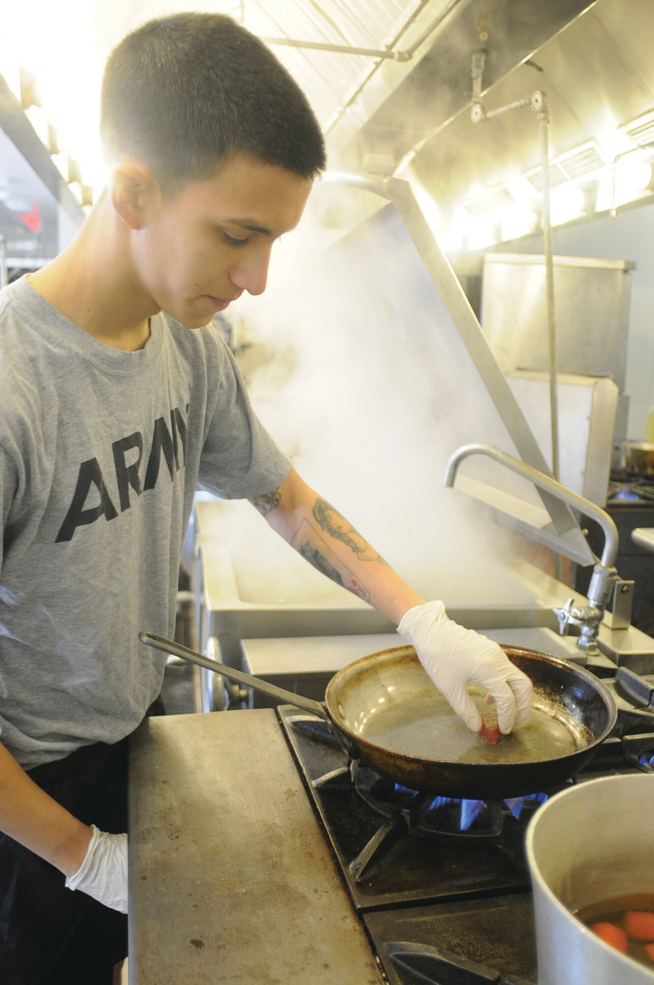 Specialist Rodriguez sears a portion of tuna in preparation for Thursday’s pre-show.
