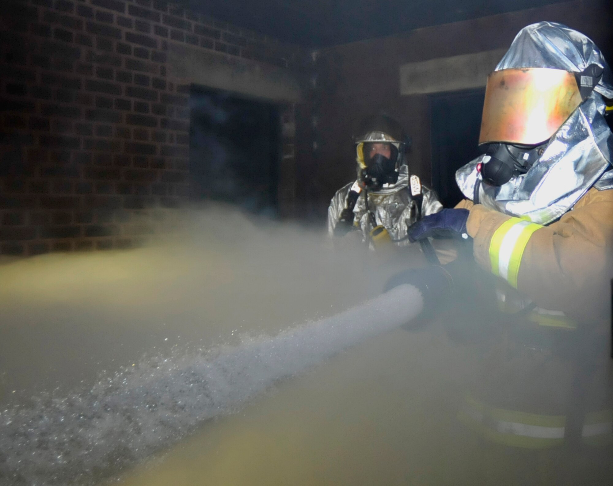 ROYAL AIR FORCE LAKENHEATH, England – Col. John Quintas, 48th Fighter Wing commander, extinguishes a fire during a readiness exercise inside the 48th Civil Engineer Squadron Smoke Training Facility on Feb. 15. Colonel Quintas participated in this exercise to understand how the 48th CES firefighters train and operate. (U.S. Air Force photo/Airman Cory Payne)