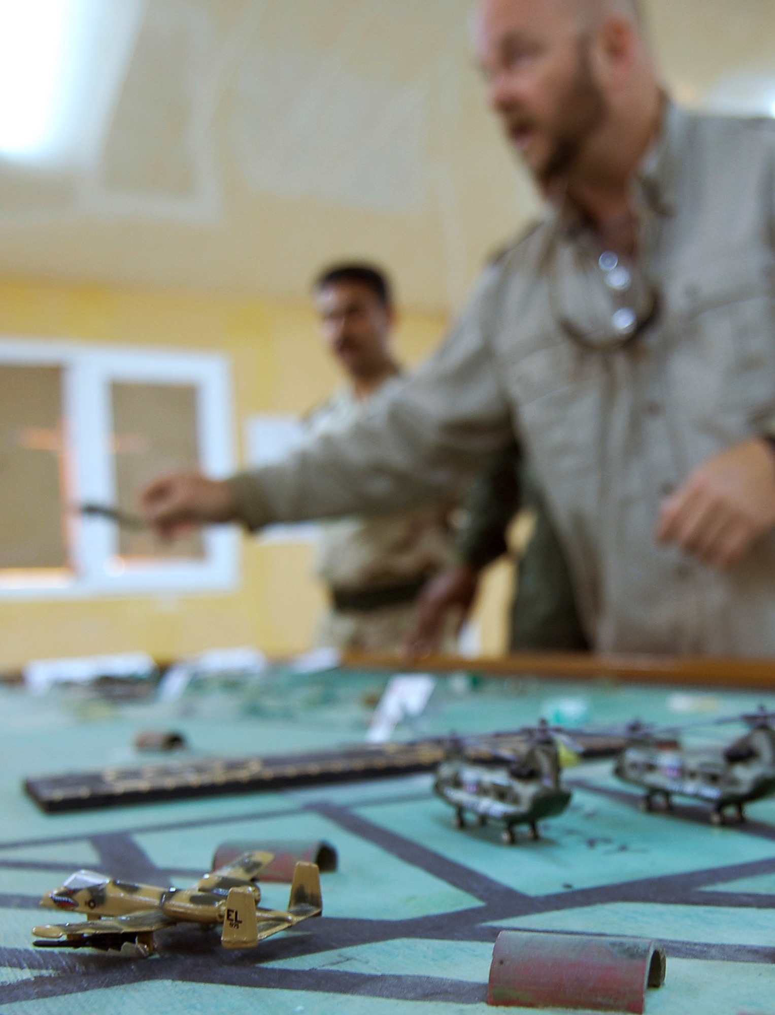 KIRKUK REGIONAL AIR BASE, Iraq -- Iraqi Air Force air traffic control students conduct Aerodrome training with guidance from Iraq Training and Advisory Mission-Air instructor, David Fowler, right. The IqAF students built a three-dimensional model airfield to better visualize concepts for departure clearances, aircraft separation distances and advanced ATC instruction in the Aerodrome course. (U.S. Air Force/Tech. Sgt. Jason Lake)