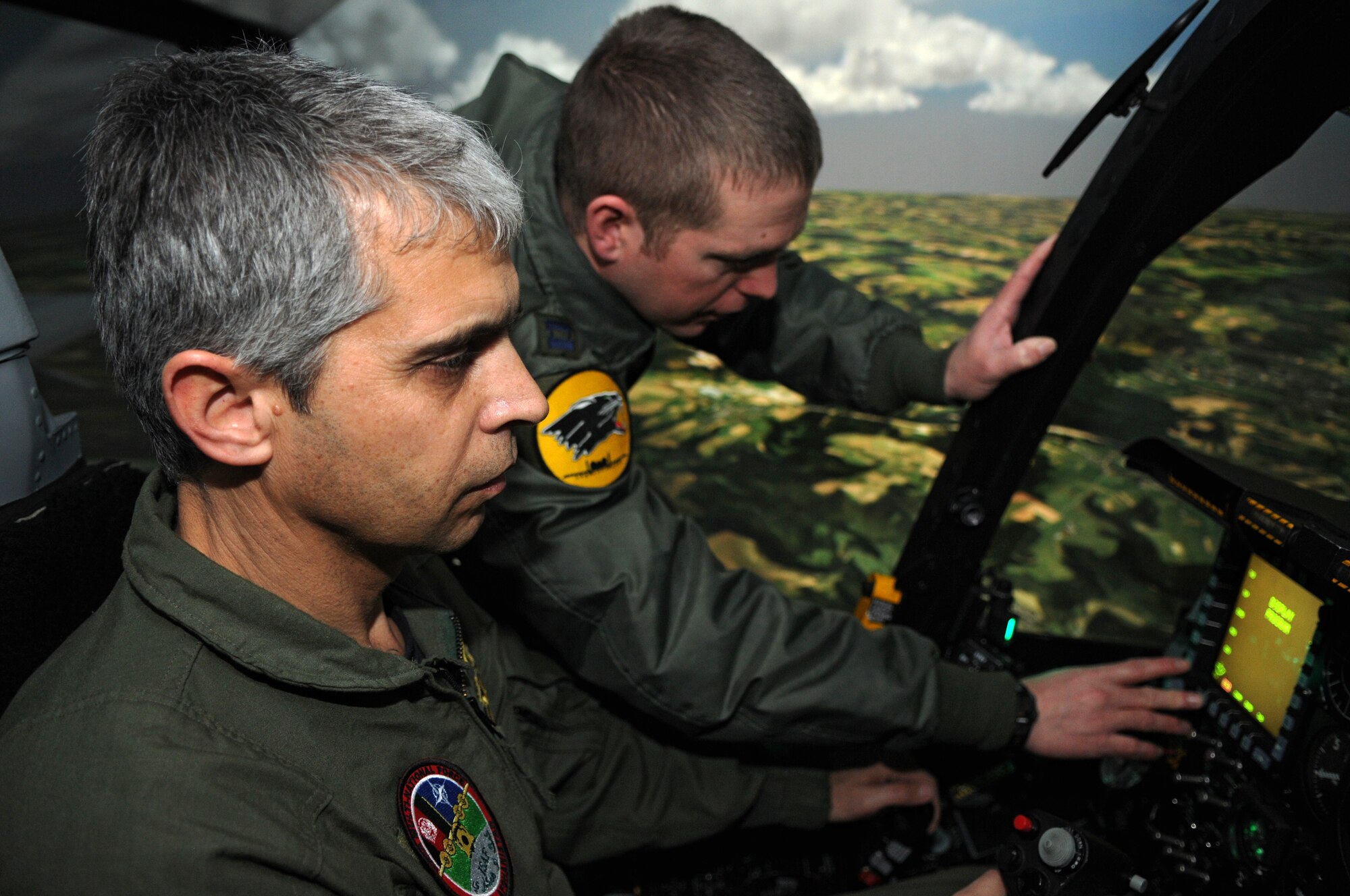 SPANGDAHLEM AIR BASE, Germany – Capt. Aaron Bigler, 81st Fighter Squadron A-10 Thunderbolt II pilot, talks with Bulgarian air force Maj. Stoyan Petkov, air traffic controller, as he flies an A-10 flight simulator here Feb. 16. Major Petkov visited from Graf Ignatievo Air Force Base, Bulgaria, with other members of the Bulgarian air force to become more familiar with U.S. Air Force air traffic control operations. (U.S. Air Force photo/Airman 1st Class Matthew Fredericks)