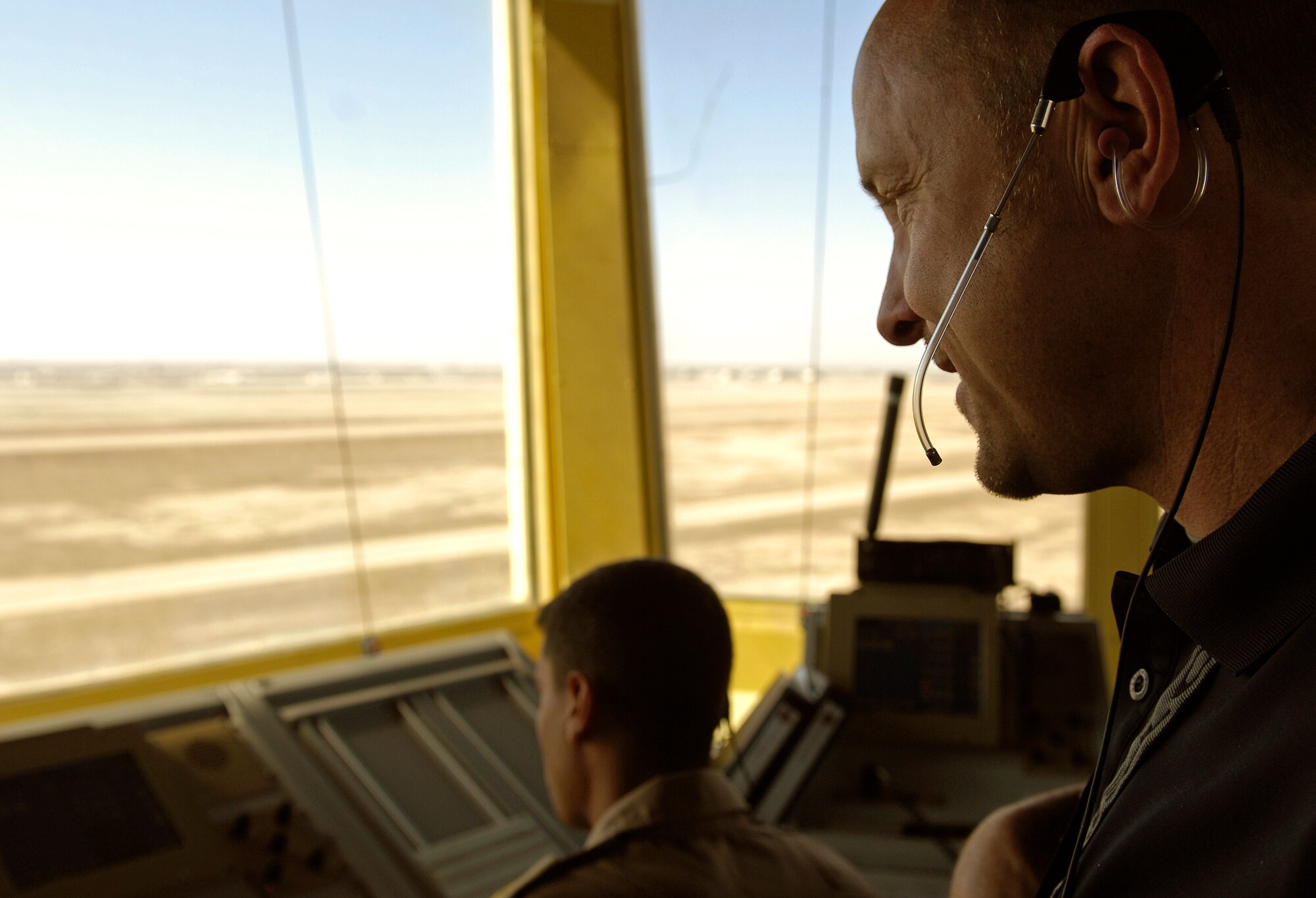 ALI AIR BASE, Iraq -- Kenneth Chappell, team lead contractor for Iraq Training and Advisory Mission–Air's air traffic control tower training, directs traffic on the airfield with the help of Iraqi air force trainees Feb. 3. Since U.S. forces began providing ATC training in 2006, six IqAF trainees have been licensed by the Iraqi Civil Aviation Authority - the equivalent to the U.S. Federal Aviation Administration - a first for the Iraqi military in modern history. (U.S. Air Force/Tech. Sgt. Jason Lake)