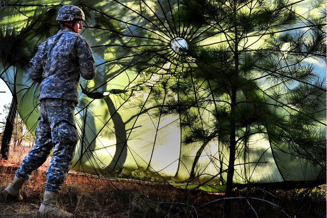 U.S. Army Pfc. Sean Murphy retreives his parachute after jumping out of a U.S. Air Force C-130 Hercules aircraft over Sicily Drop Zone on Fort Bragg, N.C., Feb. 12, 2011. Murphy is assigned to the 82nd Airborne Division's Company C, 1st Brigade Special Troops Battalion.