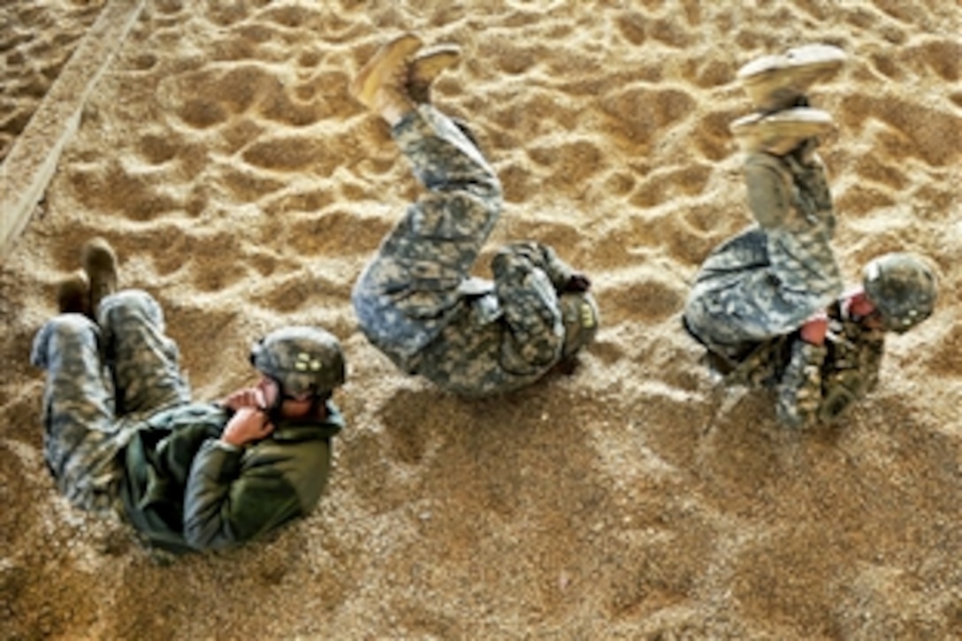 U.S. Army paratroopers practice parachute landing and rolling techniques during "Large Package Week," an exercise on Pope Air Force Base, N.C., Feb. 10, 2011. The paratroopers are assigned to the 82nd Airborne Division. The exercise uses several Air Force C-130 and C-17 aircraft to strategically airdrop troops and cargo onto a specified location to prepare for real- world response.