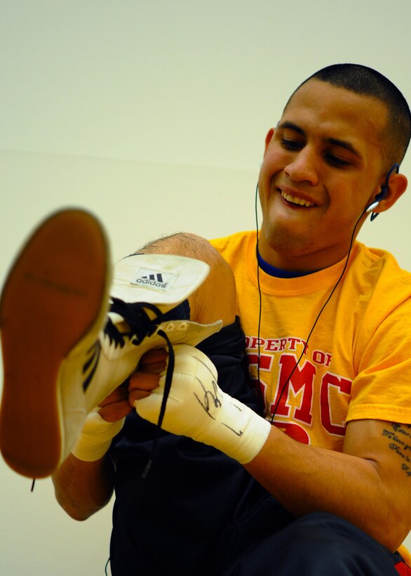 Lance Cpl. Abraham Lopez puts on his boxing shoes before his Armed Forces Boxing Championship 123-pound title fight at the Chaparral Fitness Center, Lackland Air Force Base, Texas, Feb. 18.