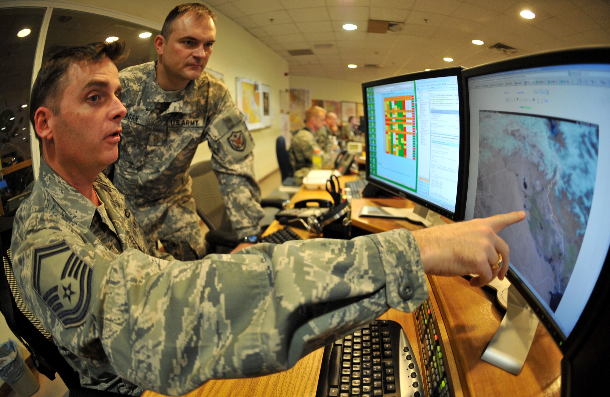 Senior Master Sgt. J. Scott Dixon, U.S. Forces-Iraq Joint Operations Center staff weather NCO in charge, briefs a member of the JOC staff about the updated weather throughout Iraq Feb. 14, 2011, at Camp Victory, Iraq. (U.S. Air Force photo by Senior Airman Andrew Lee/Released)