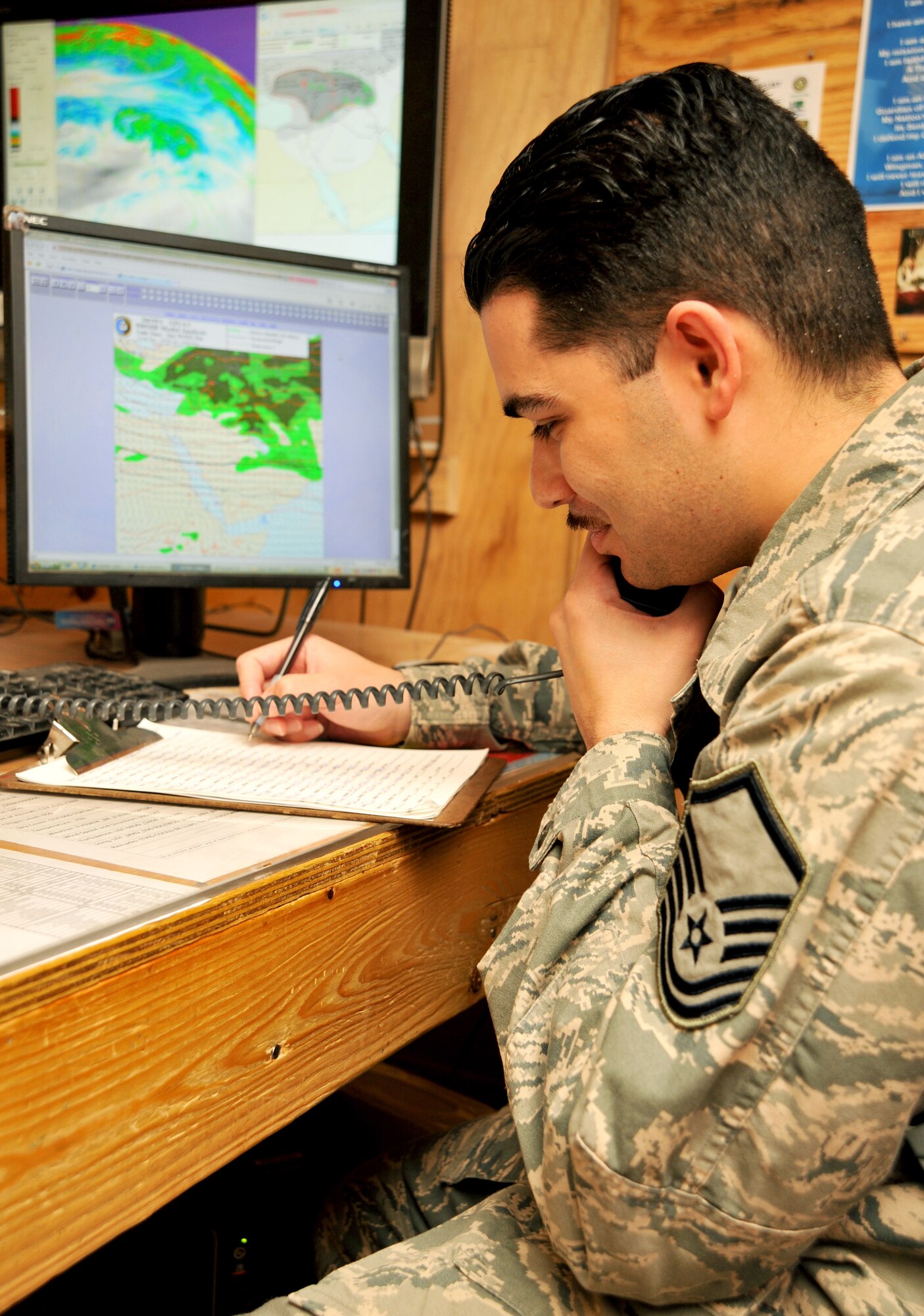 Master Sgt. Kenneth Montenegro, Task Force Observe, Detect, Identify and Neutralize staff weather office, gathers updated forecast information from a fellow battlefield Airman Jan. 28, 2011, at Contingency Operating Base Speicher, Iraq. (U.S. Air Force photo by Senior Airman Andrew Lee/Released)