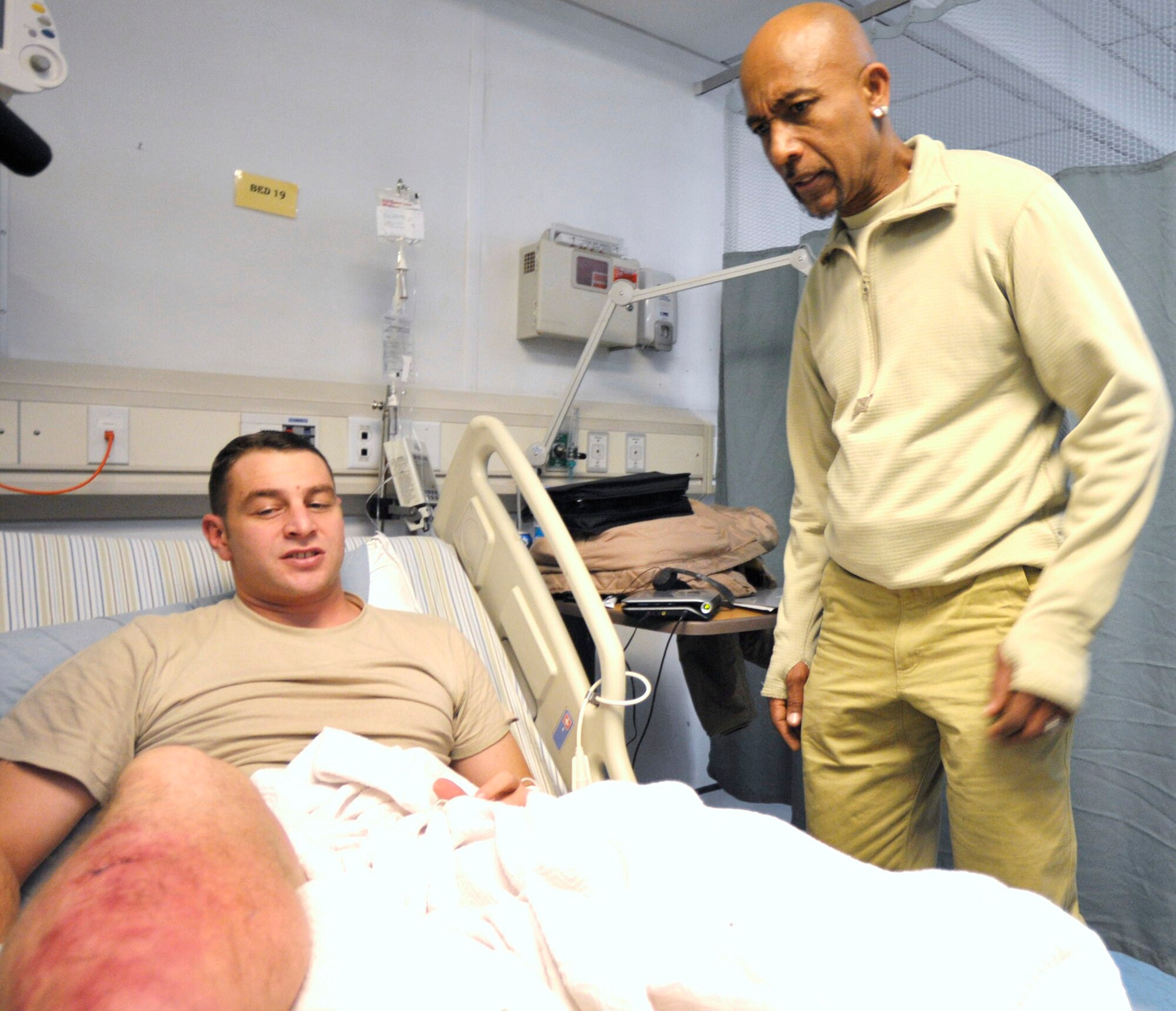 Television talk-show host Montel Williams talks to a patient at the Craig Joint Theater Hospital at Bagram Airfield, Afghanistan 19 Feb. Accompanied by International Security Assistance Force and U.S. Forces Afghanistan Senior Enlisted Leader, Command Sergeant Maj. Marvin Hill, Mr. Mark "Ranger" Jones and Col. (Ret) Bob Ulin they talked to Airmen about their deployments and thanked them for their service. (U.S. Air Force photo by Tech. Sgt. Michael Voss)    