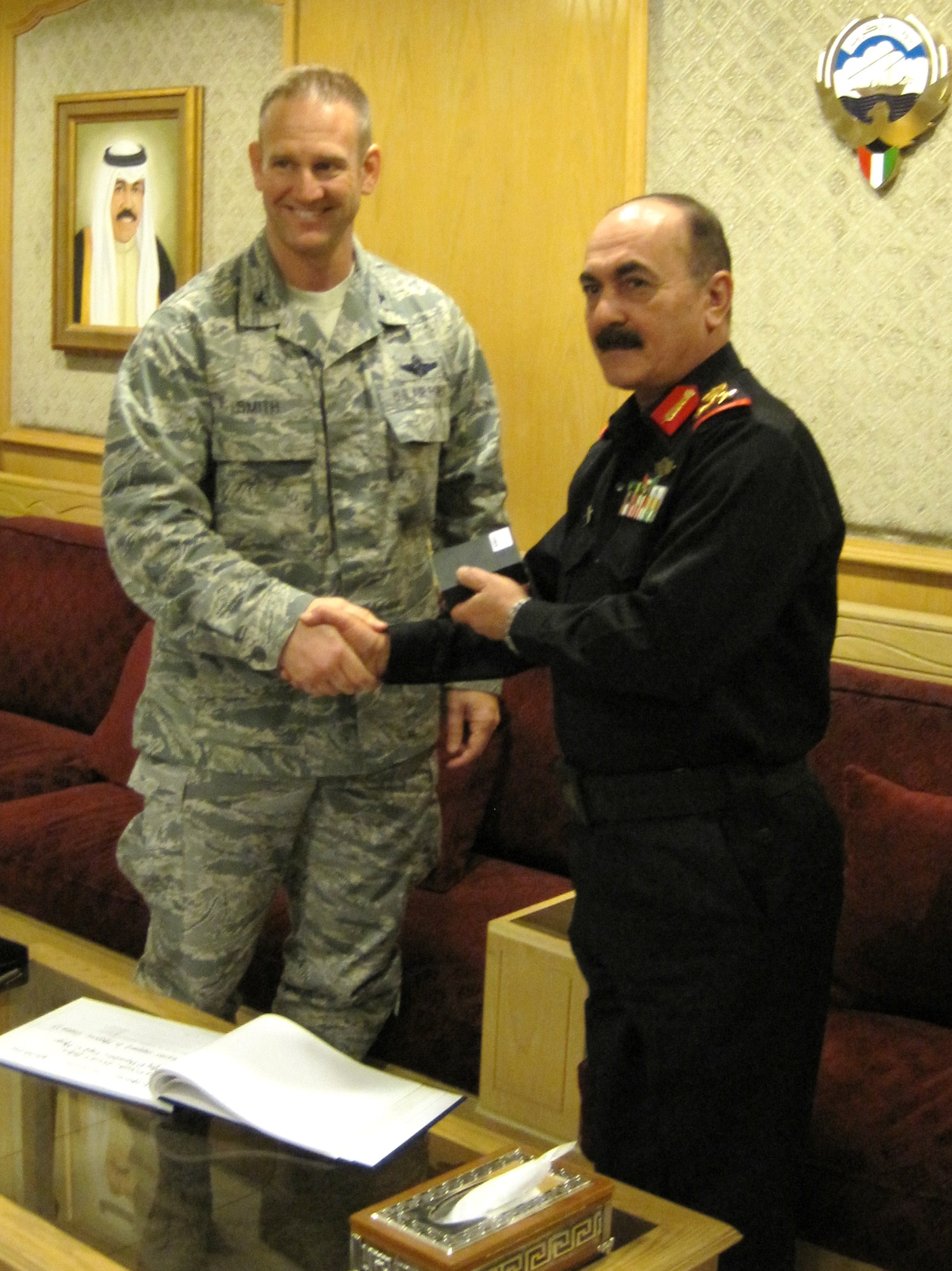 Col. Dirk Smith, 609th Air Operations Center commander, and Brig. Gen. Nasser Al Hussainan, the Mubarak Al Abdullah Joint Command and Staff College Director of Studies in Kuwait, shake hands after General Hussainan presents a token of appreciation to the U.S. Air Forces Central team for delivering “first class” presentations on current and emerging ideas from the air operations component on various military topics. For the first time ever, four U.S. Air Forces officers were invited to the school to lecture 92 students from 19 countries within the Cooperation Council for the Arab States of the Gulf. The school is generally run by British officers in partnership with Kuwaitis. (U.S. Air Force courtesy photo)