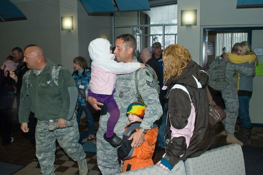 Staff Sgt. Tony Hamling (center) holds his daughter, 3-year-old Mena, and son Camron, 6,  as his wife Michele looks on to a joyful homecoming for fifteen members of the 133rd Security Forces Squadron on Feb. 20, 2011 at the St. Paul Air National Guard Base. This was the second group of fifteen returning from a six-month deployment to Iraq in support of Operation New Dawn. The Airmen handled law enforcement duties and installation security for U.S. and host nation forces at the air base located at the Baghdad International Airport. USAF official photo by Senior Master Sgt. Mark Moss