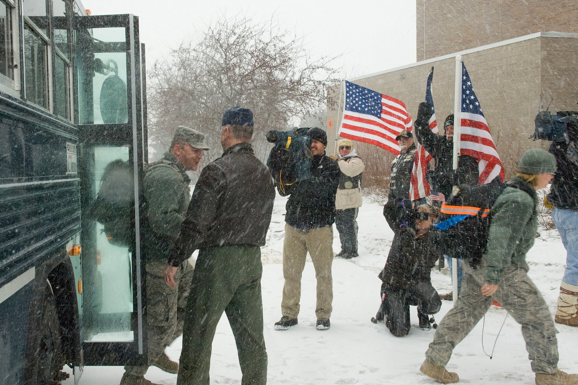 A busload of fifteen Airmen arriving from Iraq is greeted by family, friends, the Patriot Guard Riders and media as they arrive at the St. Paul Air Guard Base, 133rd Airlift Wing of the Minnesota Air National Guard, on Feb. 20, 2011. Col. Greg Haase, wing commander shakes each Airman’s hand, welcoming them home following a six-month deployment to Iraq in support of Operation New Dawn. The Airmen handled law enforcement duties and installation security for U.S. and host nation forces at the air base located at the Baghdad International Airport. USAF official photo by Senior Master Sgt. Mark Moss