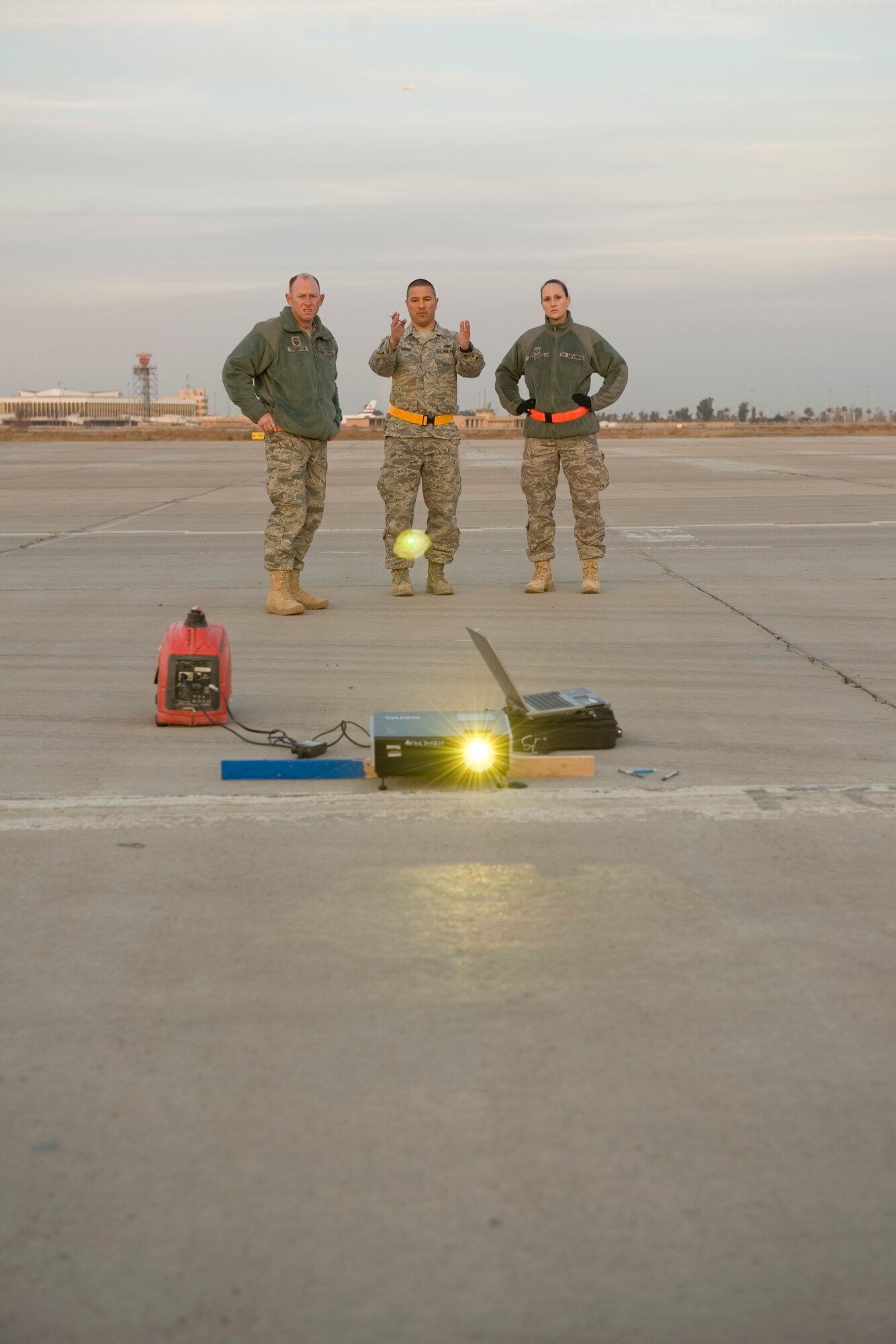 BAGHDAD -- Members of Iraq Training and Advisory Mission - Air set up a projector to help outline words on concrete barriers on Sather Air Base Jan. 24. Once the outlining was completed, they painted a mural to improve the aesthetics of the area and promote teamwork. (U.S. Air Force photo by Staff Sgt. Levi Riendeau)