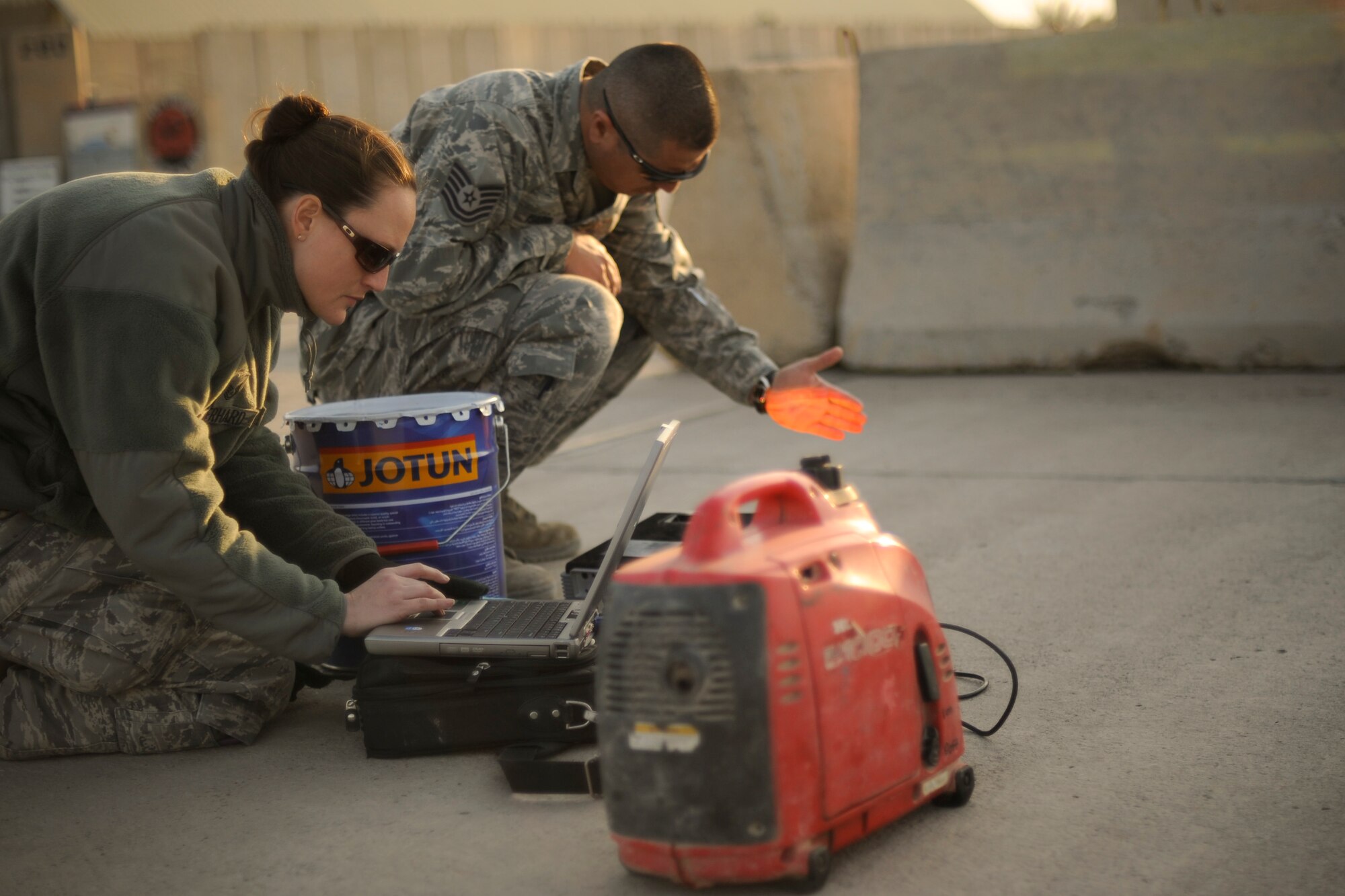 BAGHDAD -- Members of Iraq Training and Advisory Mission - Air set up a projector to help outline words on concrete barriers on Sather Air Base Jan. 24. Once the outlining was completed, they painted a mural to improve the aesthetics of the area and promote teamwork. (U.S. Air Force photo by Staff Sgt. Levi Riendeau)