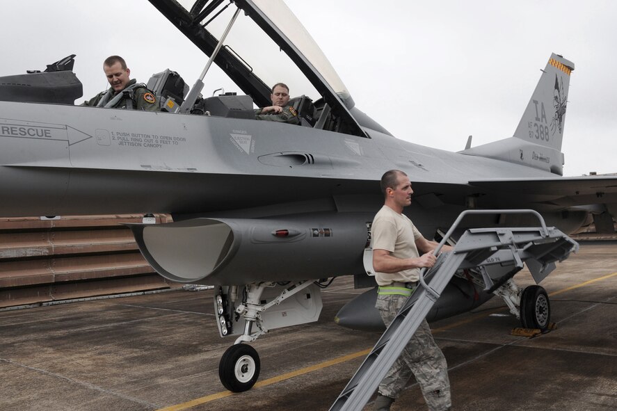 SSgt. Steve Edwards (right), of the 132nd Fighter Wing (132FW), Des Moines, Iowa, removes the crew ladder of an F-16 D aircraft in preparation to close the canopy so pilot Lt. Col. Troy Havener (cockpit, front seat) can launch and be a part of the first flight in history of 132FW F-16 aircraft from Williamtown Royal Australian Air Force (RAAF) Base, Australia on February 21, 2011. F-18 aircraft from the RAAF and the 132FW F-16's will be conducting Dissimilar Air Combat Training (DACT). The 132FW is in Australia for "Sentry Down Under" hosted annually by the RAAF.  (US Air Force photo/Staff Sgt. Linda E. Kephart)(Released)