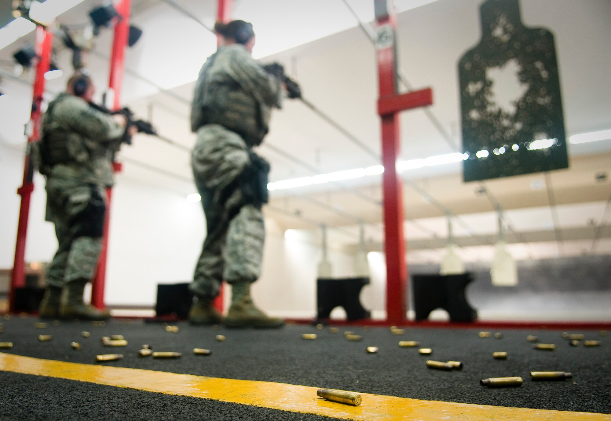 YOKOTA AIR BASE, Japan -- Tech. Sgt. Shawn Hoye and Staff Sgt. Mellissa Gschwend, 374th Security Forces Squadron patrolmen, fire their M-4 rifle during proficiency training at the small-arms range here Feb. 22. More than 700 rounds were fired in order to complete the training for the five members in attendance. (U.S. Air Force photo/Staff Sgt. Chad C. Strohmeyer)