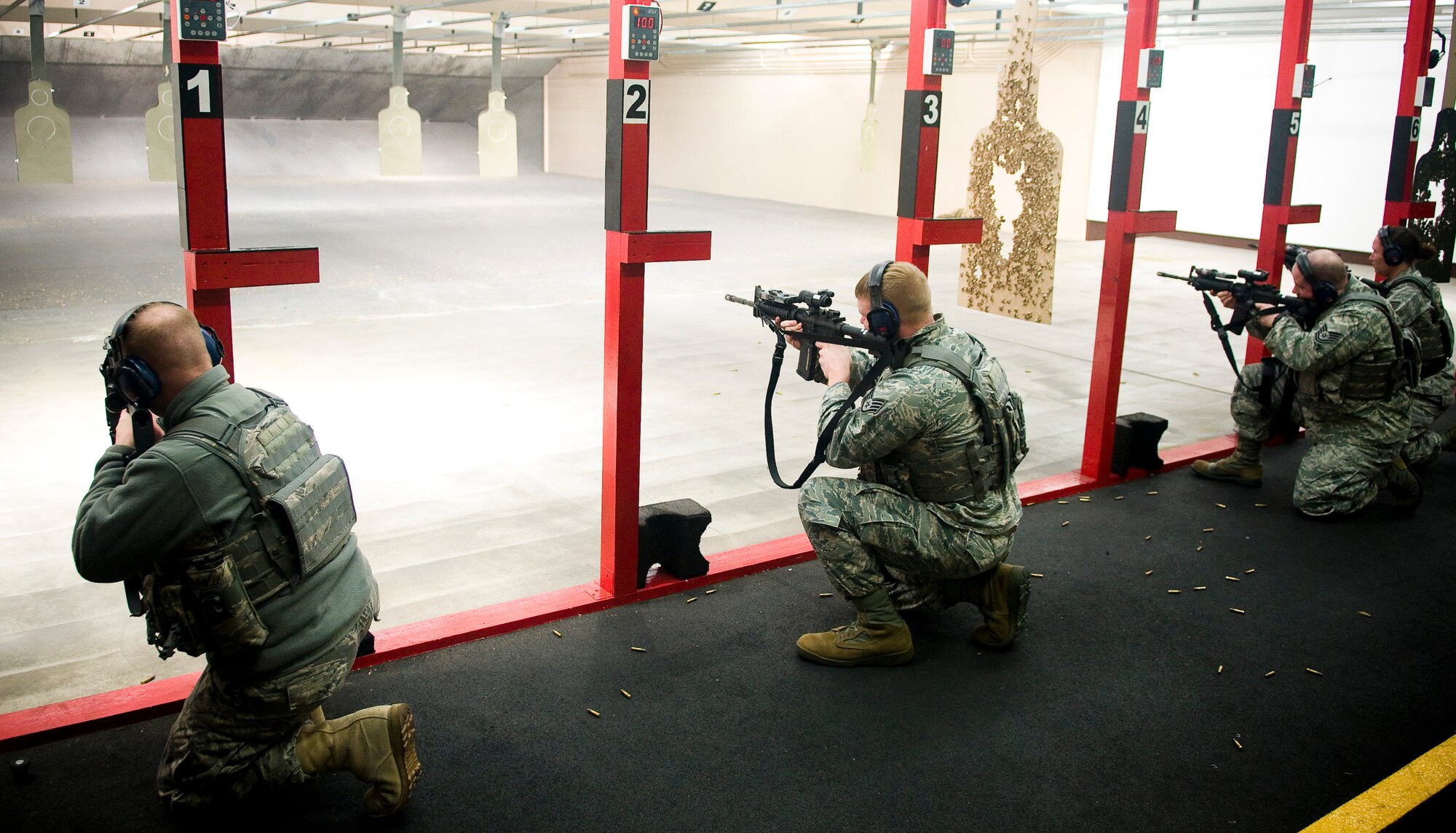 YOKOTA AIR BASE, Japan -- Members from the 374th Security Forces Squadron fire from one knee during proficiency training at the small-arms range here Feb. 22. They were required to fire from the prone position as well as fire from their strong side to their weak side. (U.S. Air Force photo/Staff Sgt. Chad C. Strohmeyer)