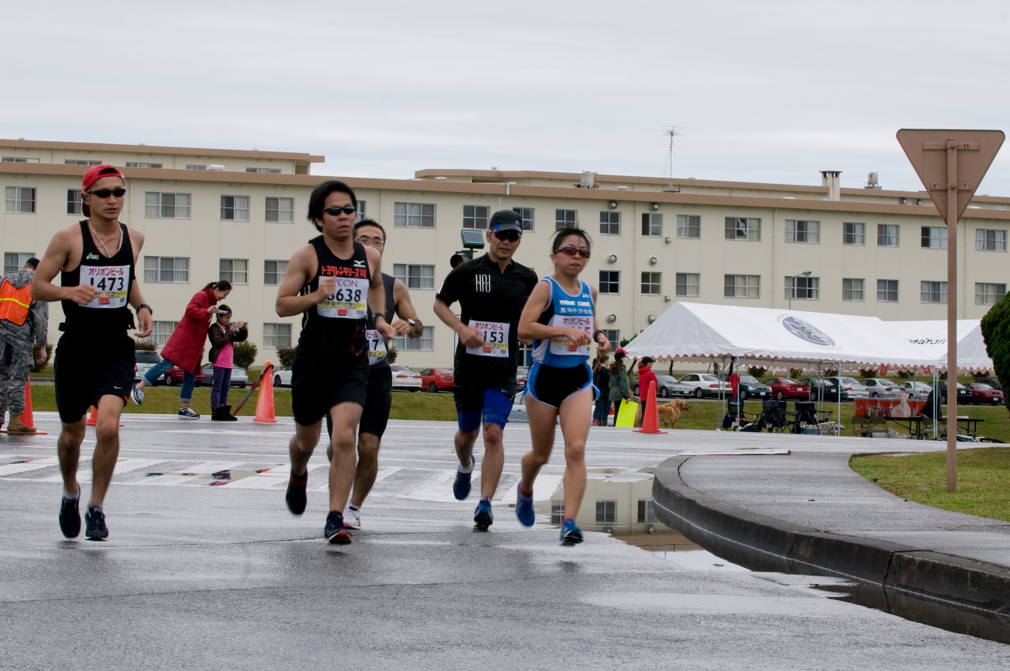A group of runners from the 2011 Okinawa Marathon round the corner near Kadena’s Gate 5 through the 1.5 mile stretch through the base, Feb. 20. Runners from the local community as well as Kadena service members participated in the 26.2 mile journey through nine different cities, towns and villages on the island, including the roughly 1.5 mile portion from Kadena’s Gate 2 to Gate 5. (U.S. Air Force photo/ Brooke P. Beers)