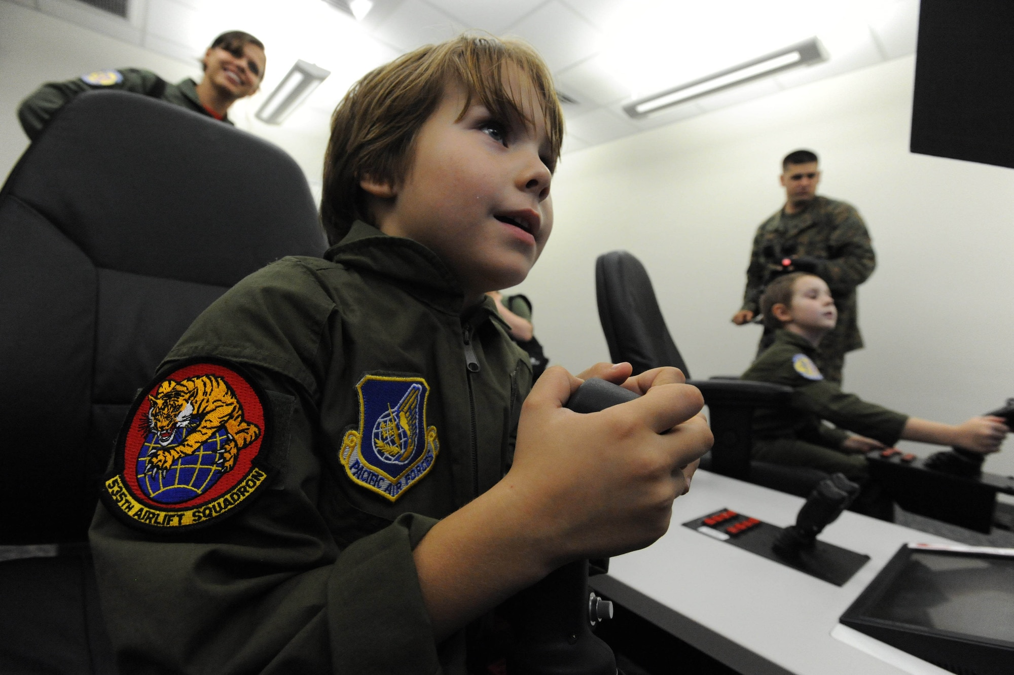 Zachary Tyrrell operates a piece of pilot training equipment before taking a C-17 Simulator ride Feb. 18 during a "Pilot for a Day" tour on Joint Base Pearl Harbor Hickam, Hawaii. The goal of the program is to benefit children and their families in the local community who have catastrophic illnesses. Haley recently been declared cancer free after recovering from a cancerous brain tumor she was diagnosed with nearly two years ago. (U.S. Air Force photo/Staff Sgt. Nathan Allen)