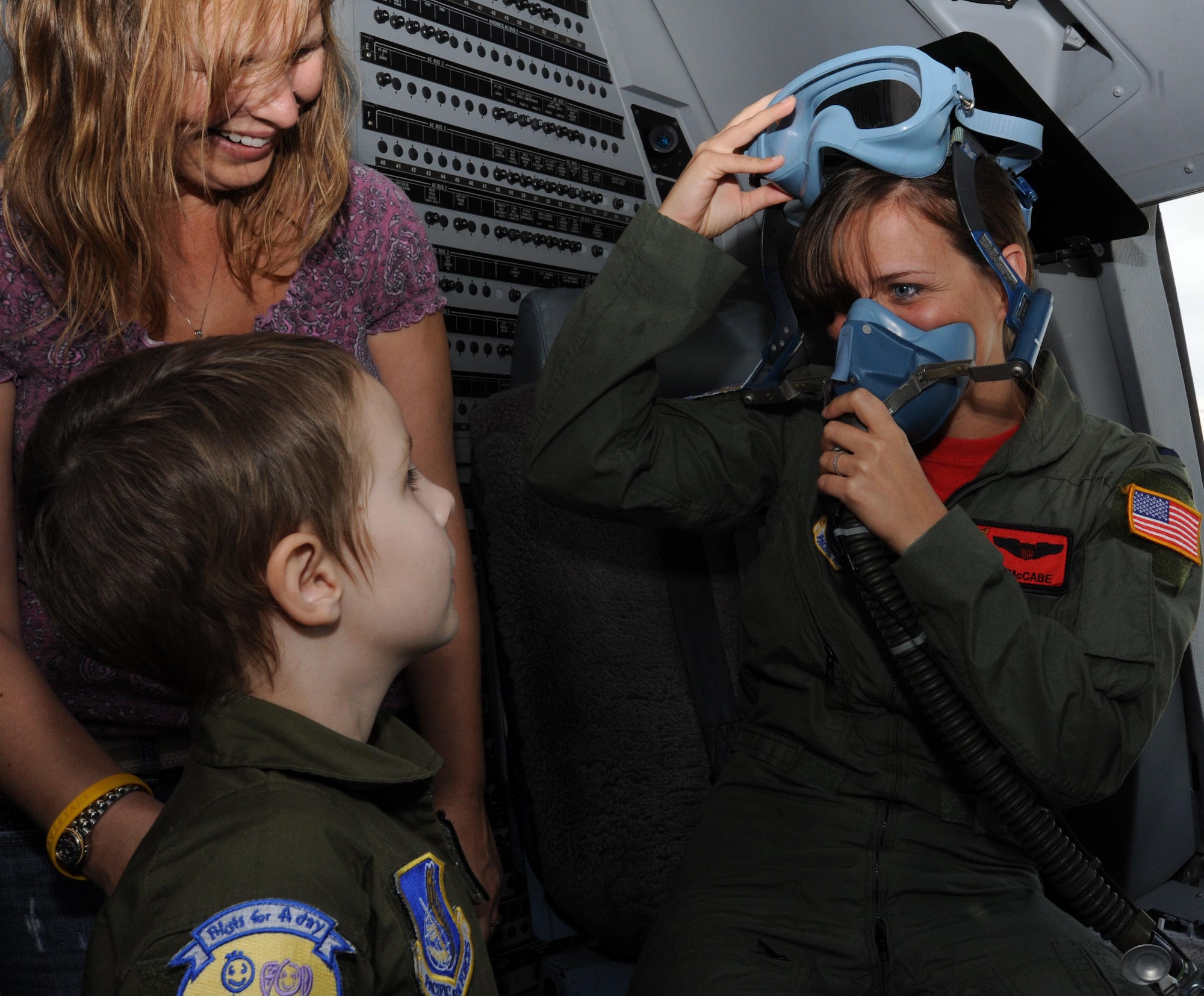 1st Lt. Audrey McCabe 535th Airlift Squadron C-17 Globemaster pilot and "Pilot for a Day" program "wingman," jests with Haley Tyrrell with the help of an in-flight oxygen mask during a C-17 static tour Feb. 18 at the kennels during a "Pilot for a Day" tour on Joint Base Pearl Harbor Hickam, Hawaii. The goal of the program is to benefit children and their families in the local community who have catastrophic illnesses. Haley recently been declared cancer free after recovering from a cancerous brain tumor she was diagnosed with nearly two years ago. (U.S. Air Force photo/Staff Sgt. Nathan Allen)