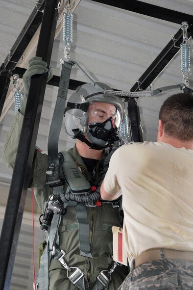 PLTOFF Mark Hannington (left), F-18 pilot from the Williamtown Royal Australian Air Force (RAAF) Base, Australia is strapped in to a parachute harness by Master Sgt. Aaron McConeghey (right), from the 132nd Fighter Wing (132FW), Des Moines, Iowa during flight training for Dissimilar Air Combat Training mission, "Sentry Down Under", which the 132FW is conducting in Australia at Williamtown RAAF Base on February 22, 2011. (US Air Force photo/Staff Sgt. Linda E. Kephart)(Released)