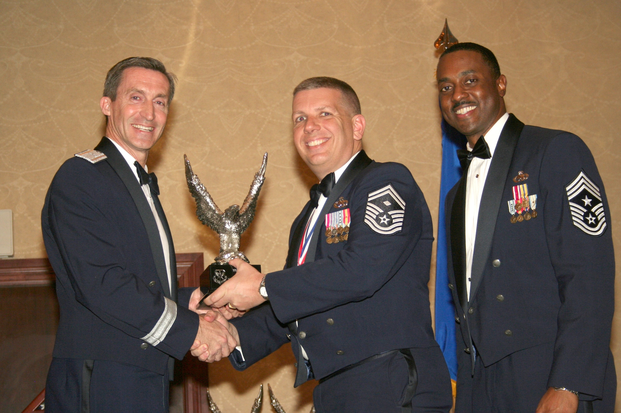 Senior Master Sgt. Sean P. Gouge, center, accepts his award as the 301st Fighter Wing's 2010 first sergeant of the year.  Sergeant Gouge is the first sergeant for the 301st Maintenance Squadron.  Presenting the award are, left, Brig. Gen. Ronald B. Miller, 301st Fighter Wing commander, and Command Chief Master Sgt. Elroy Combs, Jr.  Sergeant Gouge was one of six award recipients to cross the stage during the wing's annual awards banquet Feb. 19, 2011, at the Fort Worth, Texas, Hilton.  (U.S. Air Force photo/Staff sgt. Chris Bolen)