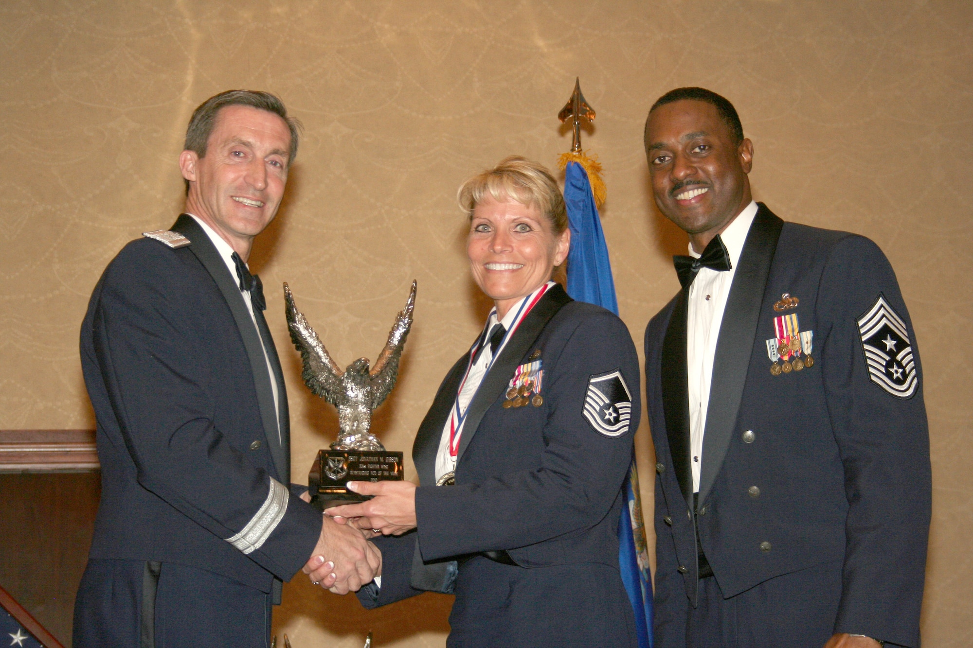Master Sgt. Mary E. Staffeld, center, accepts the 301st Fighter Wing's Senior NCO of the Year Award, Feb. 19, 2011, at the wing's annual awards banquet held at the Fort Worth, Texas, Hilton.  Presenting the award is Brig. Gen. Ronald B. Miller, left, 301 FW commander; and Command Chief Master Sgt. Elroy Combs, Jr.  Sergeant Staffeld is from the 301st Force Support Squadron and was one of six award recipients on the stage during the banquet.  (U.S. Air Force photo/Staff Sgt. Chris Bolen)