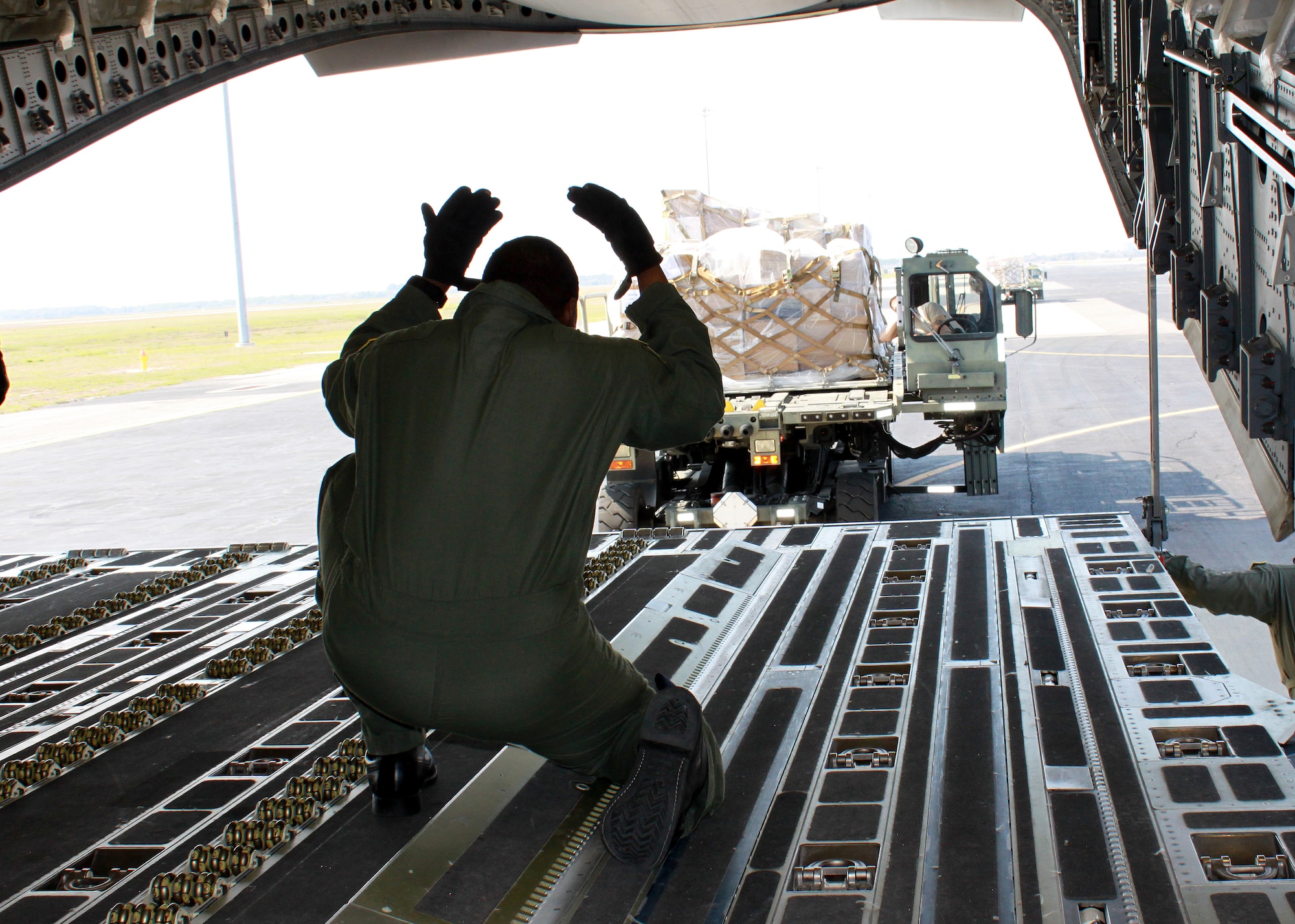 JOINT BASE MCGUIRE-DIX-LAKEHURST ? Loadmaster Tech. Sgt. Sean McClendon, 732nd Airlift Squadron, directs the positioning of cargo before uploading to the C-17 Globemaster III.  The C-17 aircrew accomplished training requirements with stops at three bases over the weekend to upload and download cargo under the Denton Program intended for delivery to Guyana and Afghanistan. The Denton Program authorizes the Department of Defense to transport donated assistance material, free of charge, on a Space Available basis and of no cost to the government other than the cost of transportation itself.