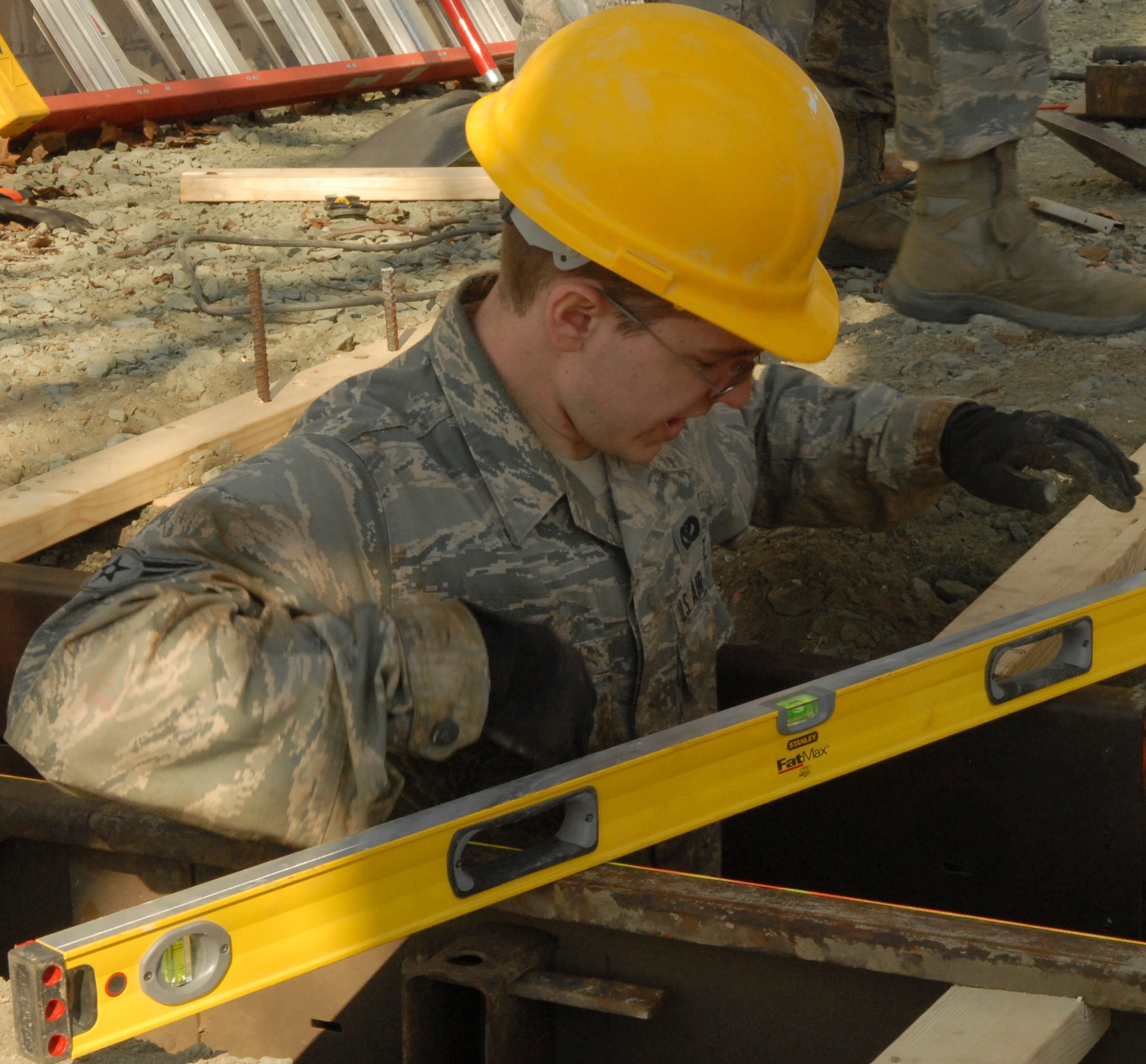 Airman 1st Class Adam Monoski, 436th Civil Engineer Squadron, ensures the form for a concrete footer is level during the Prime Base Emergency Engineer Force training project Feb. 18, 2011 at Dover Air Force Base, Del. The project is a top-to-bottom renovation of Building 205, which houses the honor guard. (U.S. Air Force/Airman 1st Class Matthew)