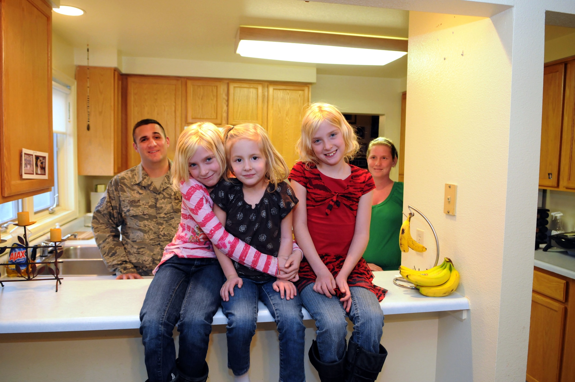 The family of Staff Sgt. Bill Chisum, 90th Medical Support Squadron, pose in the kitchen and dining area of their quarters on Wyodak Loop, F. E. Warren Air Force Base, Wyo. Chisum’s daughters are Trinity, age 9; Tessa, age 4 and Destiny, age 9. His wife, Jami, is on the right. (U.S. Air Force photo by R.J. Oriez)