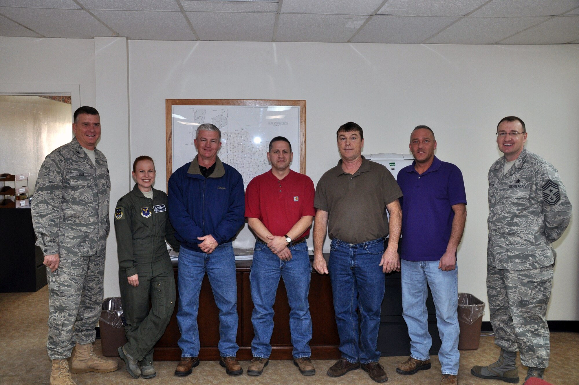 Col. Greg Tims, 90th Missile Wing commander, and Chief Master Sgt. Marty Anderson, 90th MW command chief, congratulate members of the 90th MW safety office Feb. 15, for awards the office earned at both MAJCOM and Air Force levels. (U. S. Air Foce photo by Staff Sgt. Mike Tryon)