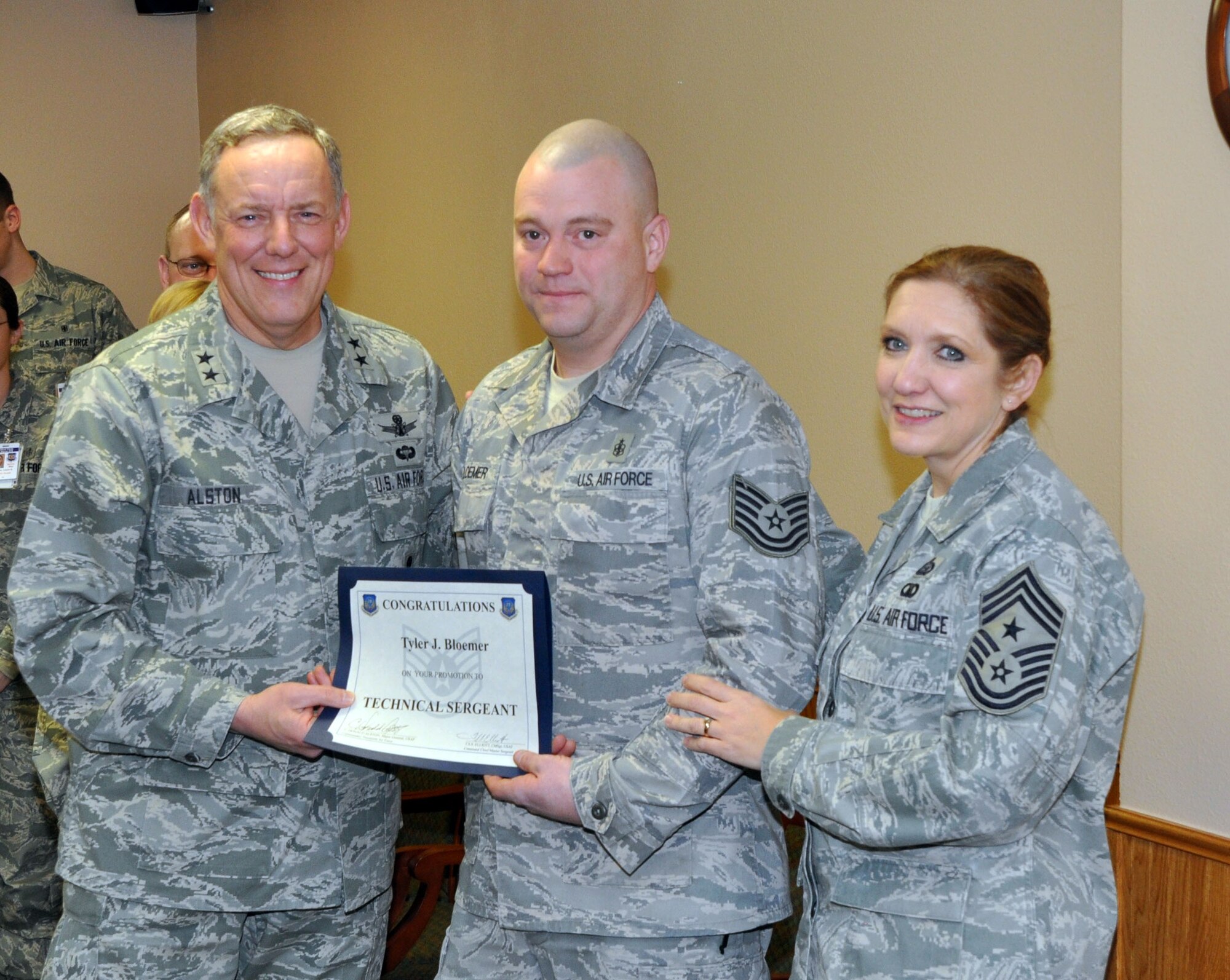 Major General C. Donald Alston, 20th Air Force commander, and Chief Master Sgt. Tammy Elliott, 20th AF command chief, surprise then Staff Sgt. Tyler Bloemer, 90th Medical Support Squadron, with a STEP promotion to Technical sergeant Feb. 15. (U.S. Air Force photo by Staff Sgt. Mike Tryon)