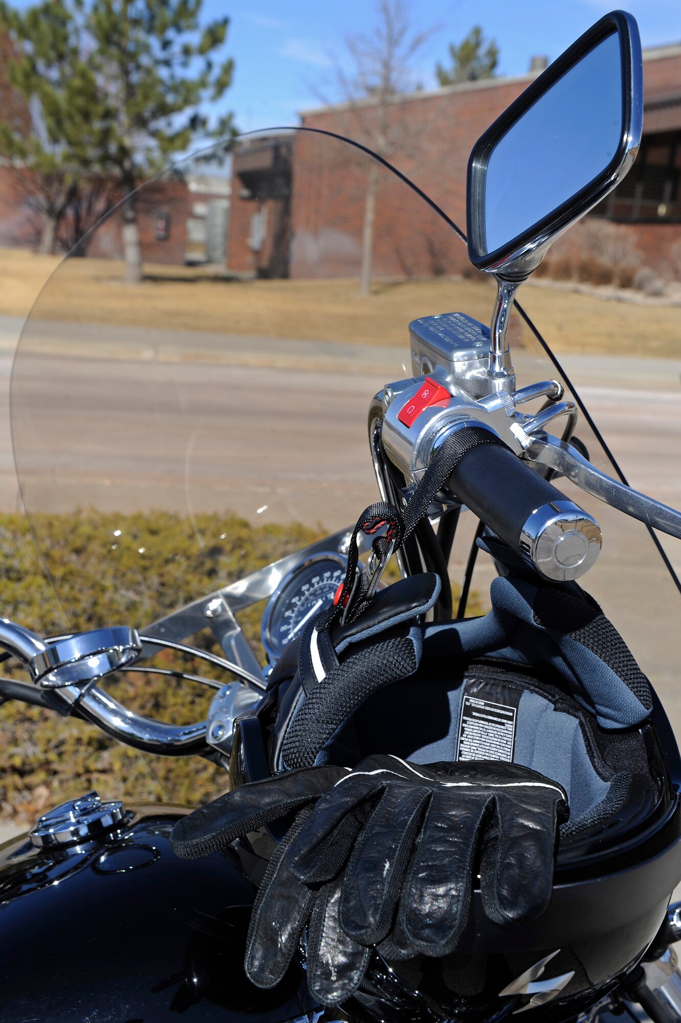 A helmet and gloves used to provide rider protection hang on the handlebars of a motorcycle on Ellsworth Air Force Base, S.D., Feb. 16, 2011.  Proper PPE consists of: head, eye and foot protection, eye protection, protective clothing such as pants and long sleeve shirts and garment and motorcycle visibility enhancers. (U.S. Air Force photo/Staff Sgt. Marc I. Lane)