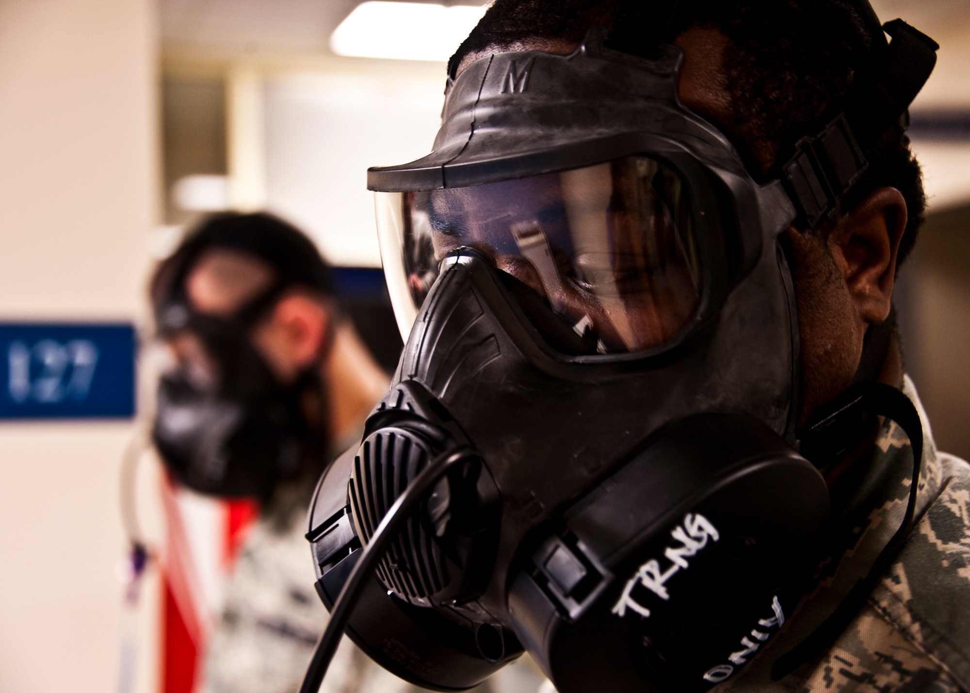 Two Airmen undergo the gas mask fit test prior to Eglin’s phase two exercise occurring Feb. 22-25.  The test is to ensure personnel are fitted to the proper size mask and to build confidence in its performance and use, according to 2nd Lt. Lindsay M. Kotouch, 96th Aerospace Medical Squadron.  The exercises used alter the seal as facial movements occur and ensure the mask to face seal is not broken and won't allow contamination into the mask.  (U.S. Air Force photo/Samuel King Jr.)