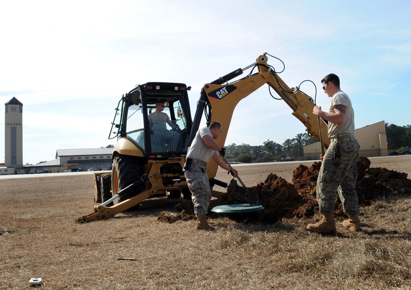 MOODY AIR FORCE BASE, Ga. -- Members from the 23rd Civil Engineer Squadron fill a hole with dirt after inserting a lift station Feb. 15. When burying the lift station, it is necessary to use caution to ensure the lift station remains level so the equipment can be placed precisely. (U.S. Air Force photo/Airman 1st Class Douglas Ellis)(RELEASED)
