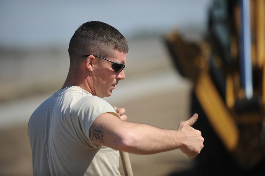 MOODY AIR FORCE BASE, Ga. -- Staff Sgt. Cecil Barnhill, 23rd Civil Engineer Squadron water and fuel system maintenance craftsman, uses hand signals to direct another 23rd CES member using a trencher Feb. 15. This particular piece of equipment was used to dig a trench and level excess dirt. (U.S. Air Force photo/Airman 1st Class Douglas Ellis)(RELEASED)
