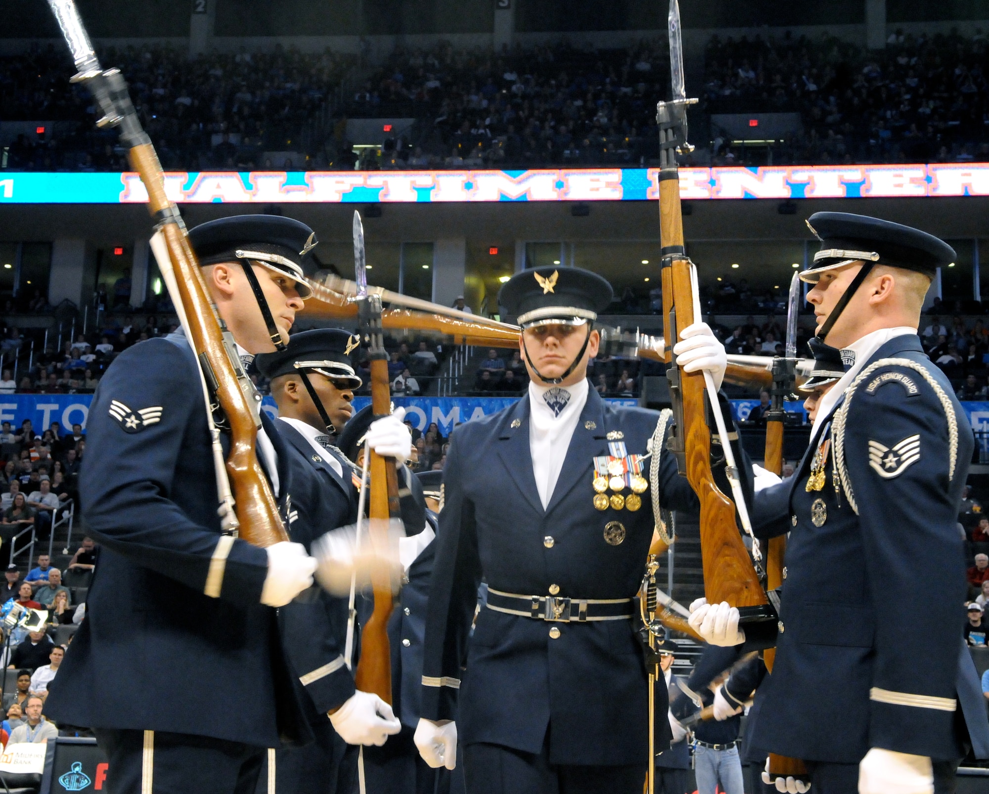 Tech. Sgt. Michael Doss, member of The U.S. Air Force Honor Guard drill team, walks through the line of twirling M-1 rifles during a performance Feb. 15 at the Oklahoma City Thunder’s military appreciation night. The performance is Sergeant Doss’ final performance with drill team. (U.S. Air Force photo by Airman 1st Class Tabitha N. Haynes)