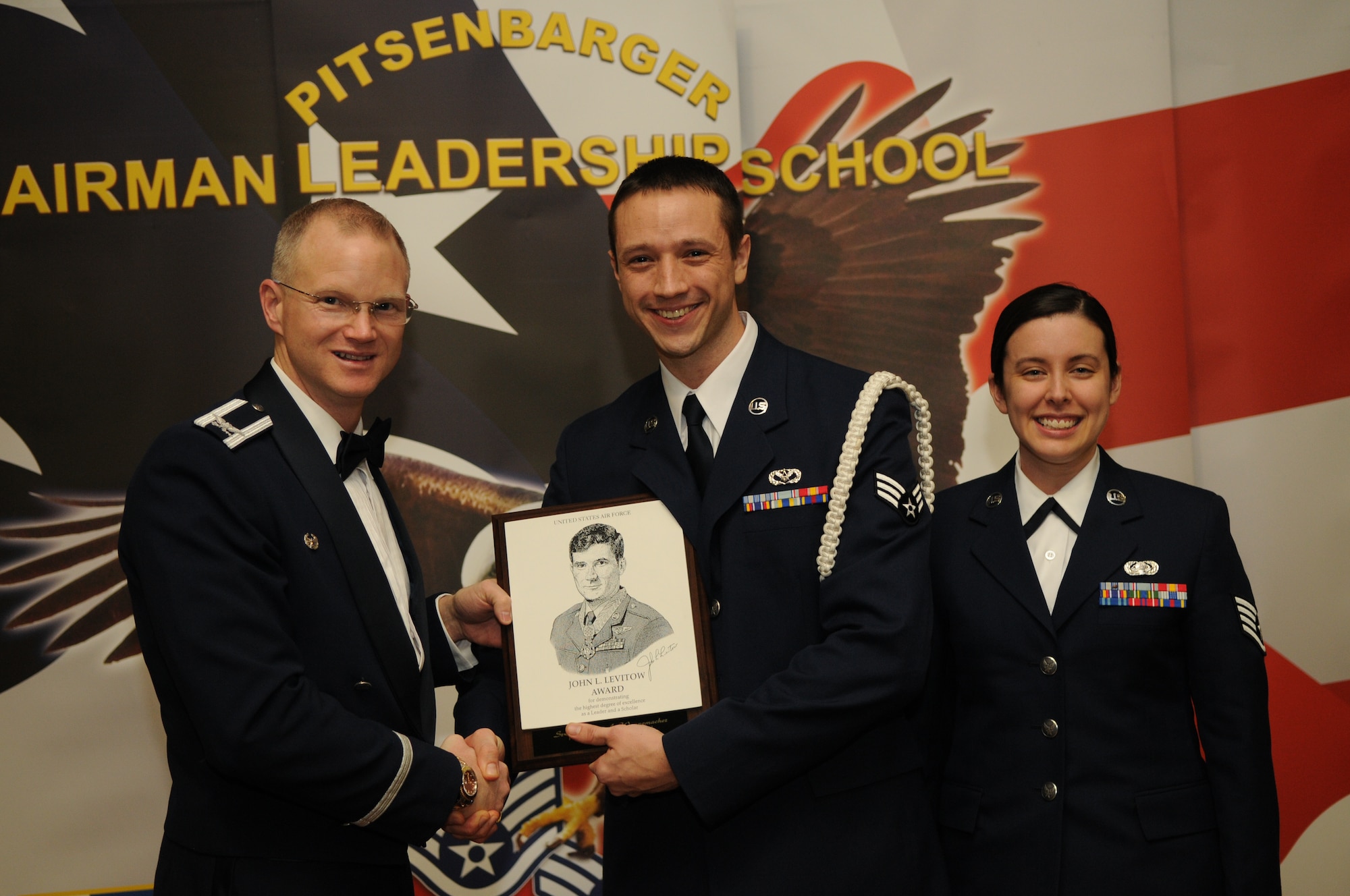 SPANGDAHLEM AIR BASE, Germany -- Senior Airman Kevin Wannemacher, 52nd Civil Engineer Squadron, accepts the John L. Levitow award from Col. Christopher Weggeman, 52nd Fighter Wing commander and Staff Sgt. Michelle Godlstrom, previous John L. Levitow award recipient, during the Pitsenbarger Airman Leadership School Class 11-C graduation at Club Eifel Feb. 16. The John L. Levitow award is the highest award an Airman can receive upon completion of ALS. (U.S. Air Force photo/Airman 1st Class Matthew B. Fredericks)