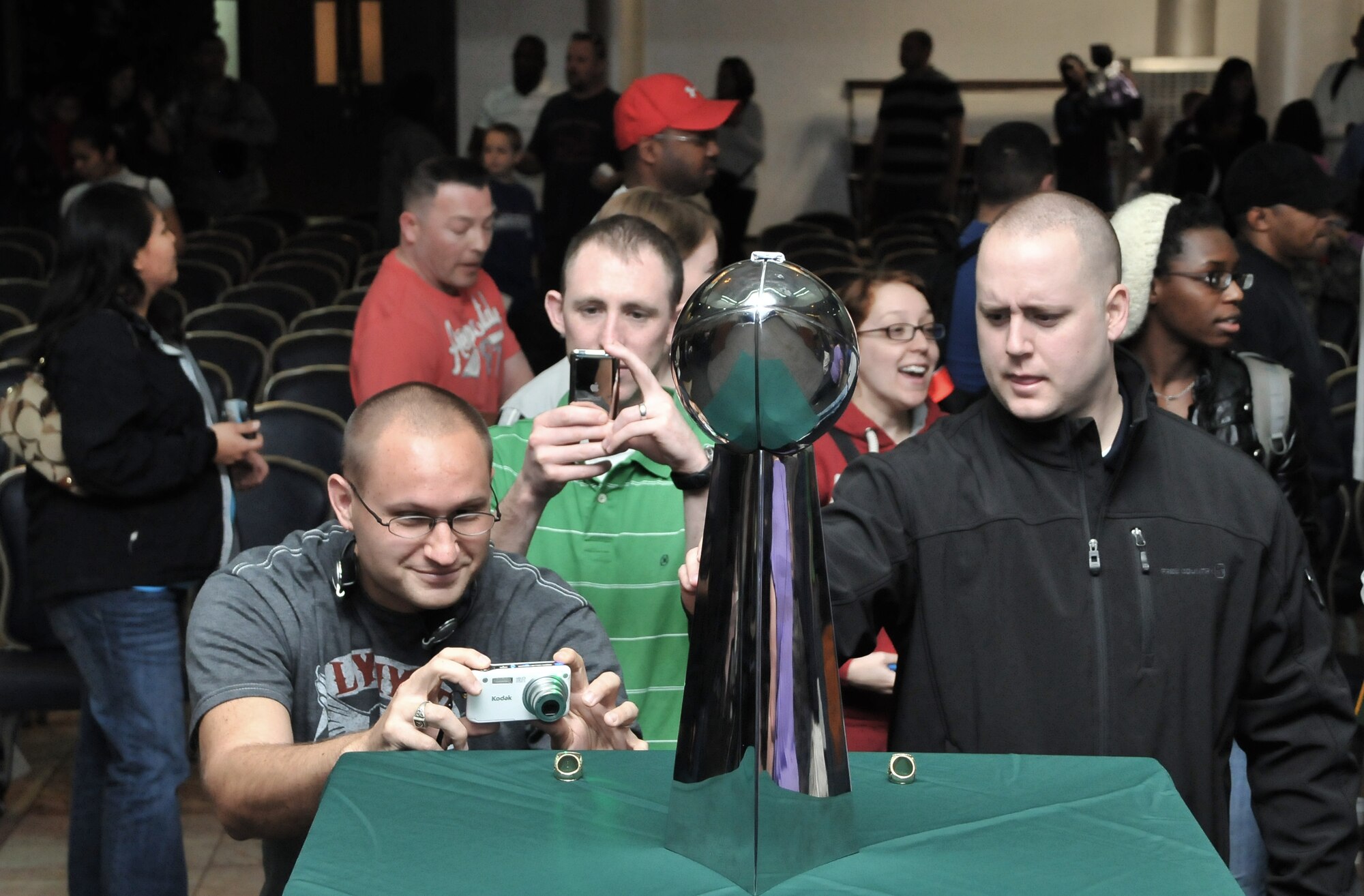 Incirlik Airmen take photos of and with a replica of the National Football League Vince Lombardi Trophy and Super Bowl XLV championship rings during a visit from the NFL team the Green Bay Packers to Incirlik Air Base, Turkey, Feb. 12, 2011. The trip was organized by Navy Entertainment and the 39th Force Support Squadron as part of the team’s “Tundra Tour.” Super Bowl XLV champions Jarrett Bush, Derrick Martin, William Henderson, Frank Zombo, Nick McDonald, and Daryn Colledge, as well as Pepper Burruss, the head athletic trainer for the Packers, conducted a behind-the-scenes presentation and an autograph session during their visit to the base. (U.S. Air Force photo by Staff Sgt. Alex Montes)

