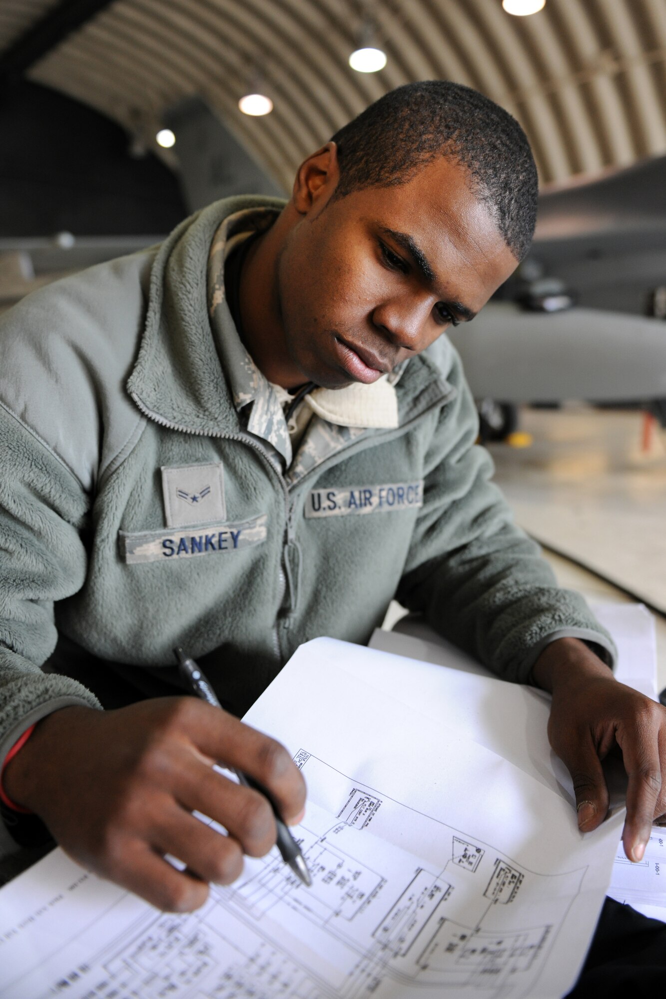 KUNSAN AIR BASE, Republic of Korea -- Airman 1st Class Deymond Sankey, 134th Expeditionary Fighter Squadron, reviews a schematic in a technical compliance order manual before performing routine maintenance on an F-16 Fighting Falcon here Feb. 22. (U.S. Air Force photo/Tech. Sgt. Jonathan Pomeroy) 