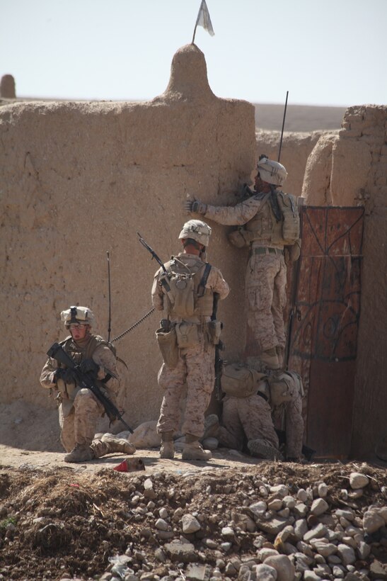 U.S. Marine Corps Cpl. Michael J. Sulzener, a team leader with 2nd Squad, hoists Cpl. Mitchel R. Atkins, squad leader for 2nd Squad, 1st Platoon, Company L, Battalion Landing Team 3/8, 26th Marine Expeditionary Unit, Regimental Combat Team 8, to the top of a compound wall while on a security patrol near Combat Outpost Ouellette in Helmand province, Afghanistan, Feb. 23, 2011. Elements of the 26th Marine Expeditionary Unit deployed to Afghanistan to provide regional security in Helmand province in support of the International Security Assistance Force.