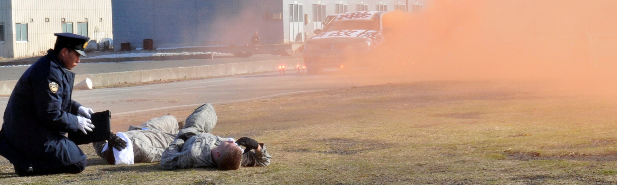 A Japanese National Police officer assesses (simulated) injuries of two U.S. Air Force Airmen during a Misawa City major accident exercise Feb. 23, 2011, Misawa City, Japan. This was the first exercise conducted by U.S. Air Force and Misawa City emergency responders that involved an aircraft accident. (U.S. Air Force photo by Tech. Sgt. Phillip Butterfield/Released)  