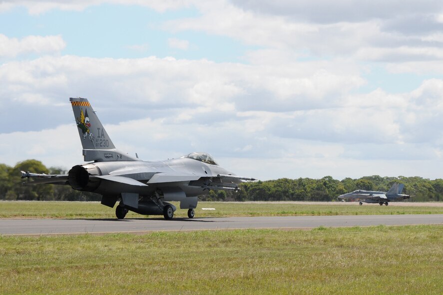 In preparation to launch during joint flying mission, "Sentry Down Under", an F-16 C+ aircraft from the 132nd Fighter Wing (132FW), Des Moines, Iowa is seen taxiing on the runway behind an F-18 aircraft at the Royal Australian Air Force (RAAF) Base, Williamtown, Australia on February 23, 2011.  The 132FW and RAAF are currently involved in Dissimilar Air Combat Training in Australia.  (US Air Force photo/Staff Sgt. Linda E. Kephart)(Released)