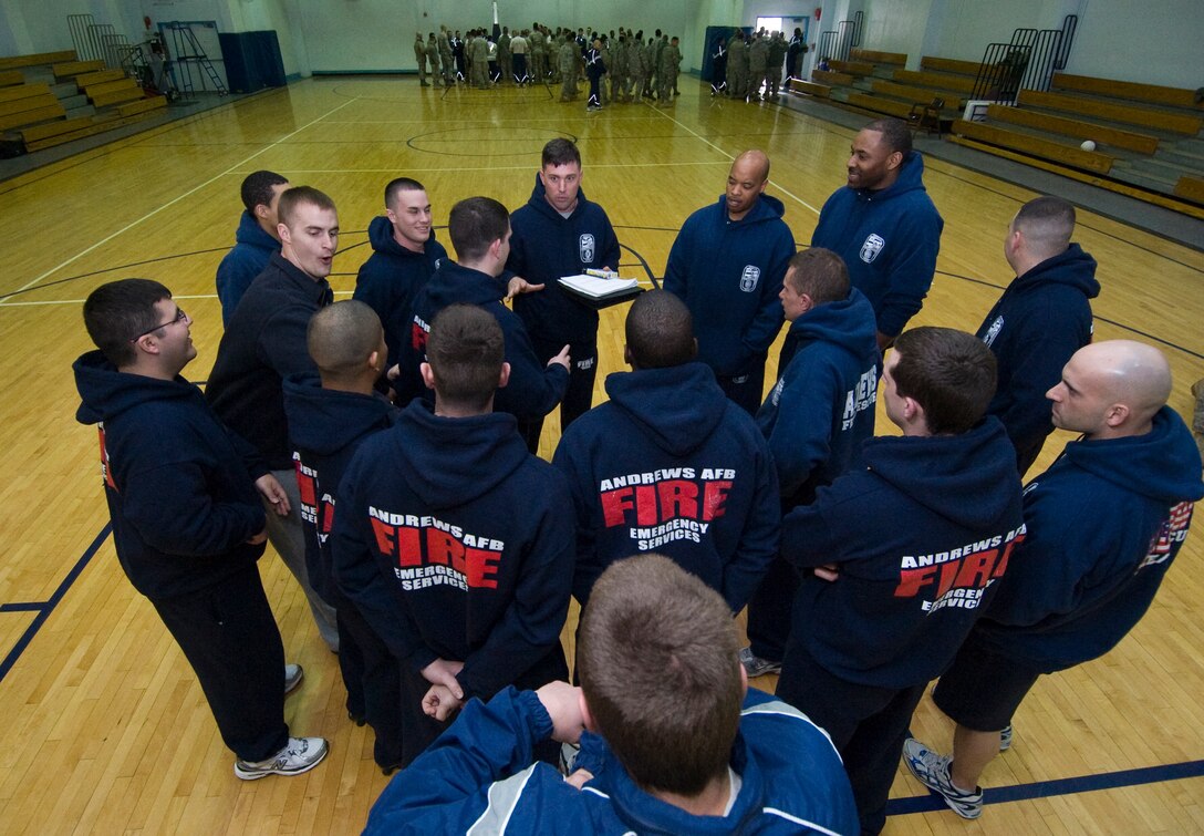 Technical Sgt. Joshua Ashton, top center,11th Civil Engineer Squadron logistics officer, discusses a plan of attack with a group of fellow 11 CES firefighters prior to a game of dodge ball at the East Fitness Center Feb. 22. The purpose of the activity was to hone team-building skills. (U.S. Air Force photo/Bobby Jones)