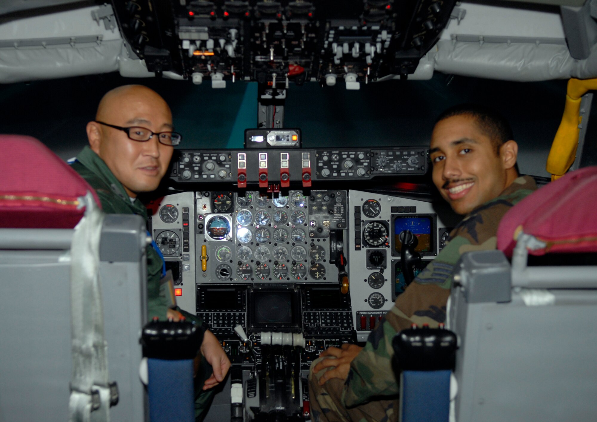 Tech. Sgt. Ryoichi Kaj, a Japanese Air Self Defense Force member from Kasuga Air Base, and Staff Sgt. Timothy Allen of the 18th Civil Engineer Squadron pose for a photo while touring the KC-135 simulator on Kadena Air Base, Feb. 23.  Sergeant Kaji, and seven other JASDF members, took part in an exchange program that gave American and Japanese Airmen an opportunity to gain an understanding of each other’s jobs. (U.S. Air Force photo/Airman 1st Class Tara A. Williamson)