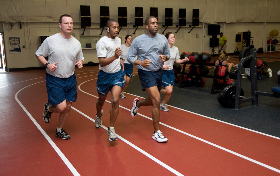 A group of 11th Wing Staff members run the perimeter of an indoor track as part of their weekly physical fitness training session at the West Fitness Center Feb. 18. (U.S. Air Force photo/Bobby Jones)