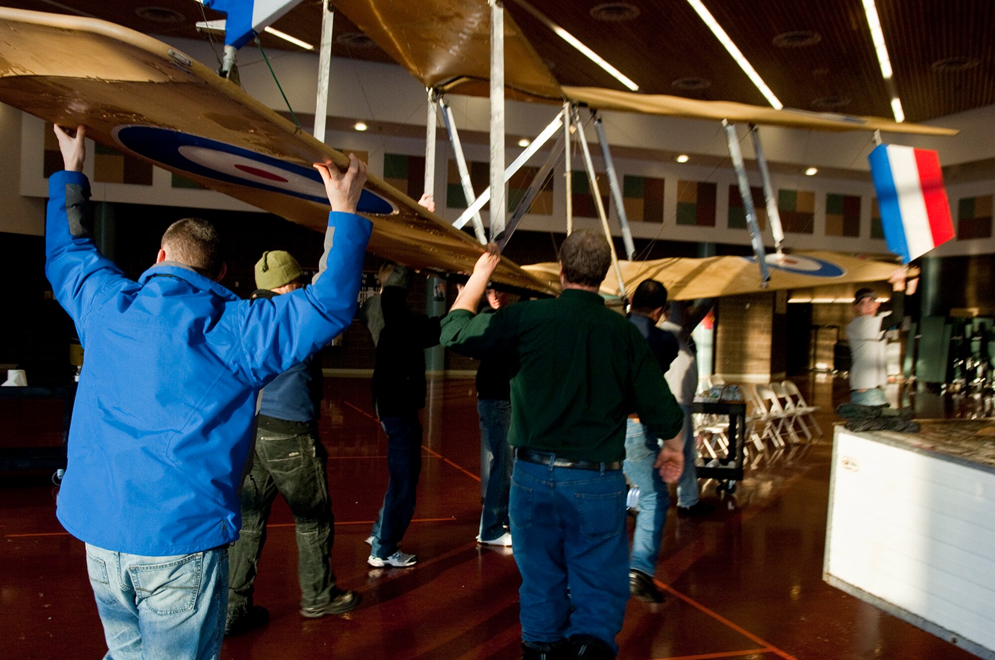 ANCHORAGE, Alaska -- Volunters from Joint Base Elmendorf-Richardson move an ultra-light model plane in Begich Middle School for the Build-a-Plane program Feb. 12. The Build-a-Plane program is designed to inspire children to become involved in aviation. (U.S. photo/Airman 1st Class Jack Sanders)