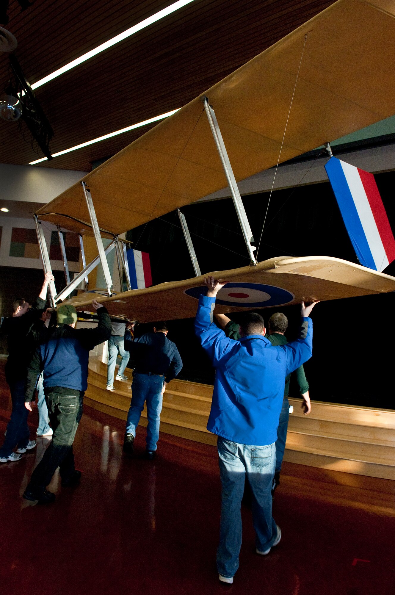 ANCHORAGE, Alaska -- Volunters from Joint Base Elmendorf-Richardson move an ultra-light model plane in Begich Middle School for the Build-a-Plane program Feb. 12. The Build-a-Plane program is designed to inspire children to become involved in aviation. (U.S. photo/Airman 1st Class Jack Sanders)